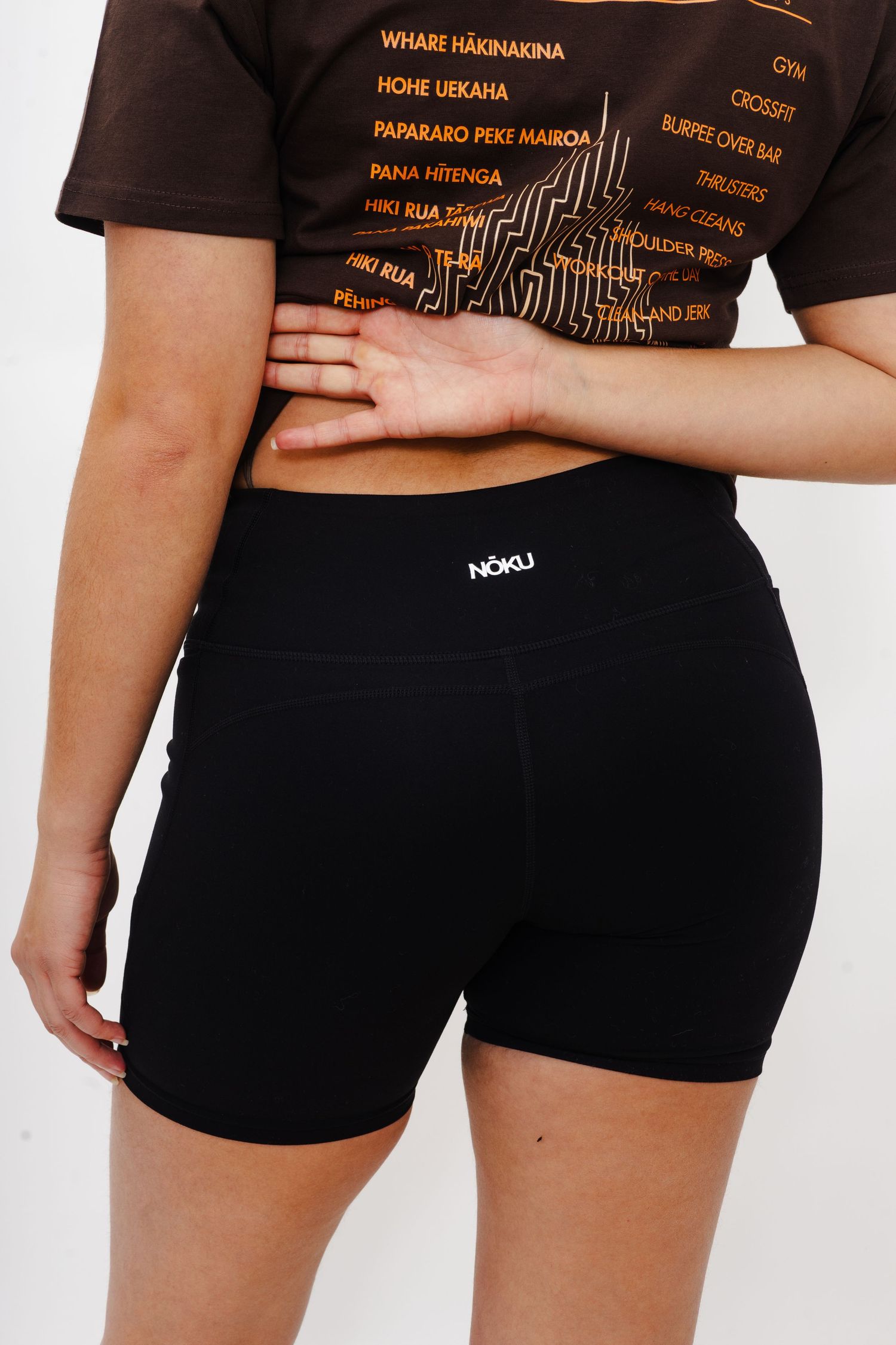 Back view of black athletic shorts with NOKU logo on waistband.