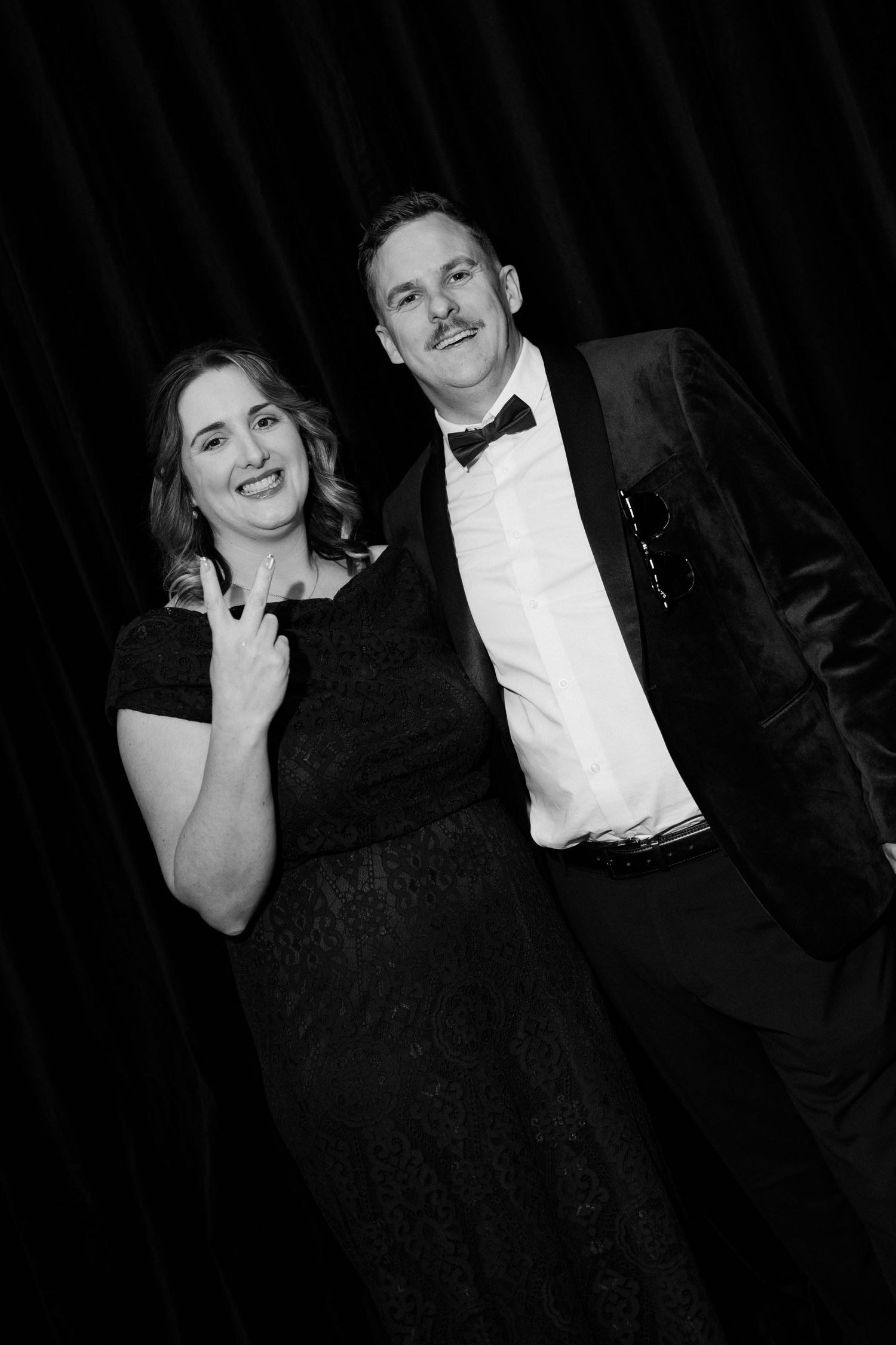 A couple in formal attire poses together in a series of black and white photo booth style shots.