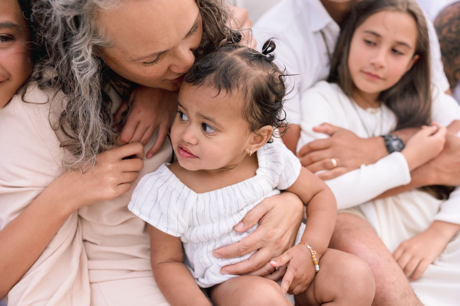 A tender moment captured in soft tones as a mother and child share an intimate embrace while lying down together.