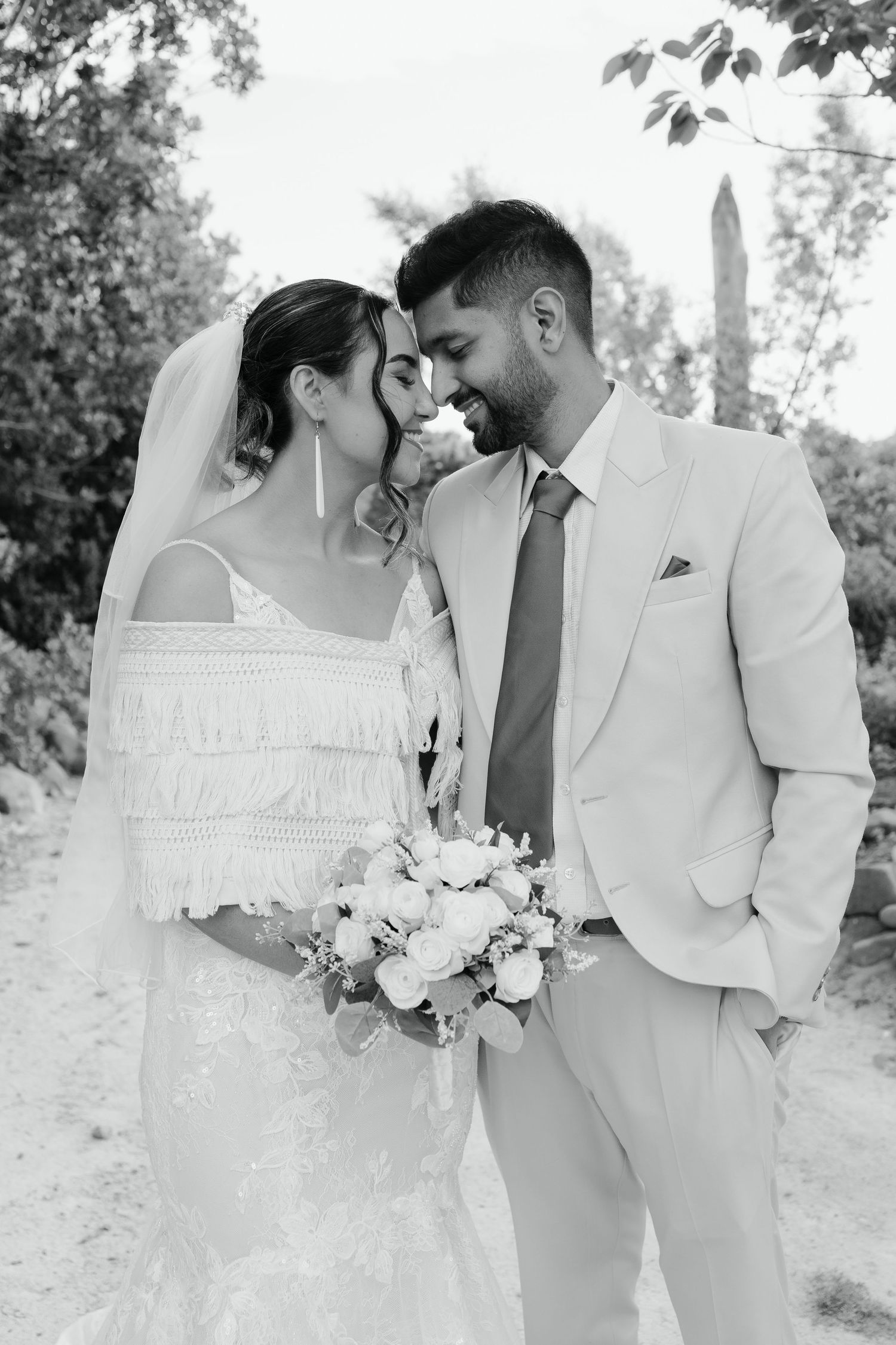 A romantic black and white wedding photo series showing tender moments between newlyweds in an outdoor garden setting.