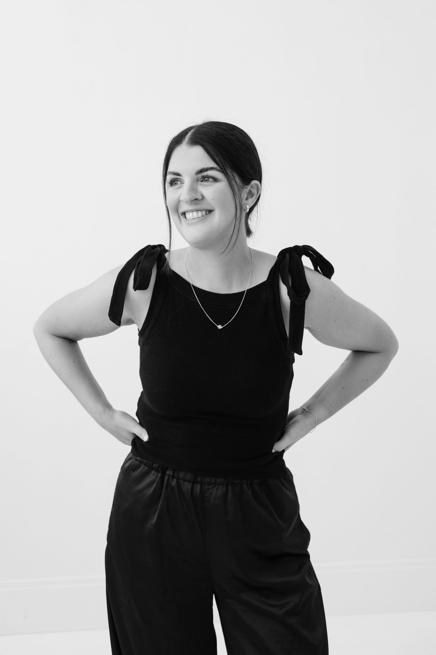 Four black and white studio portraits showing a woman in a black dress posing against a white background.