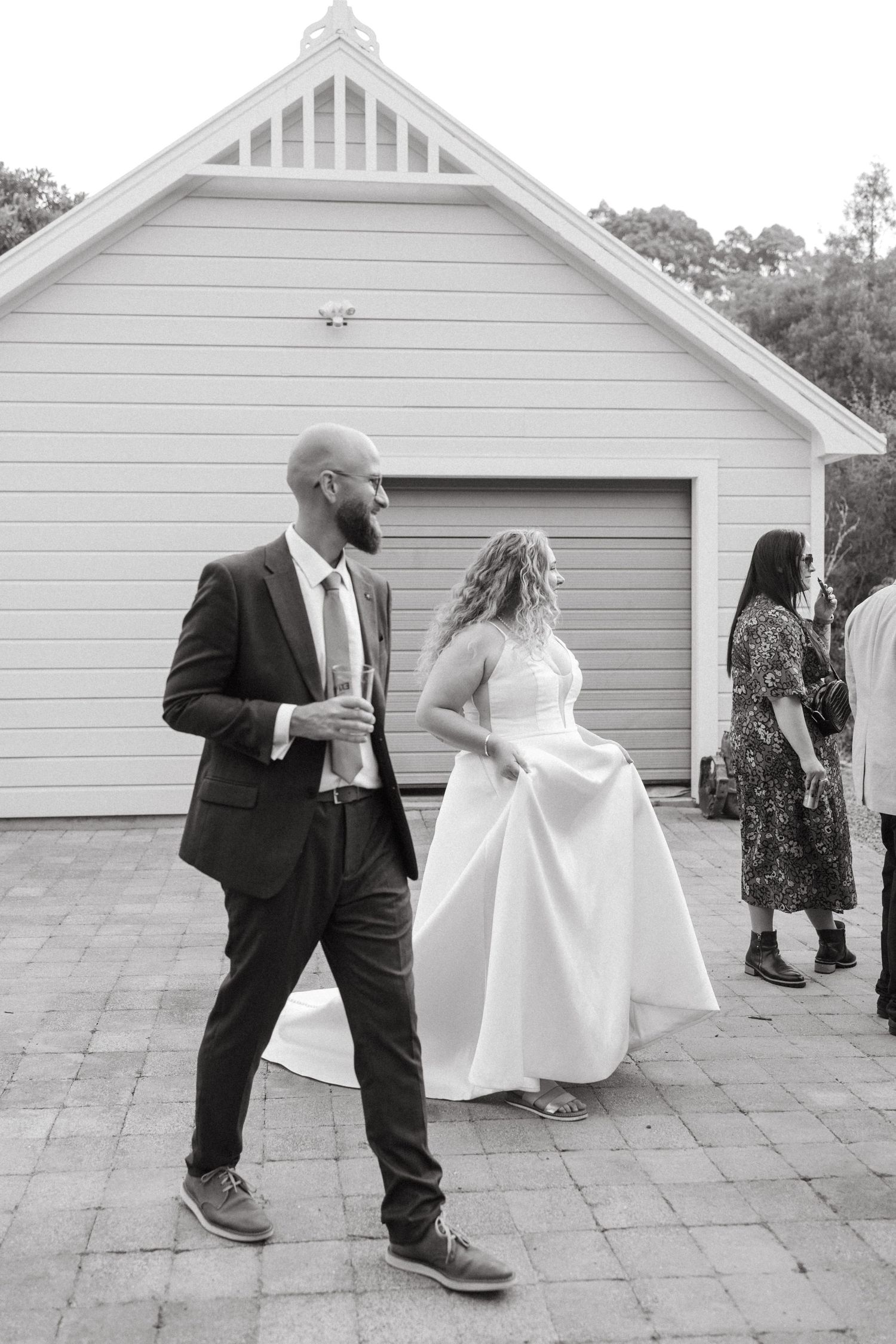 Series of dance moves between couple in front of white garage at wedding reception.