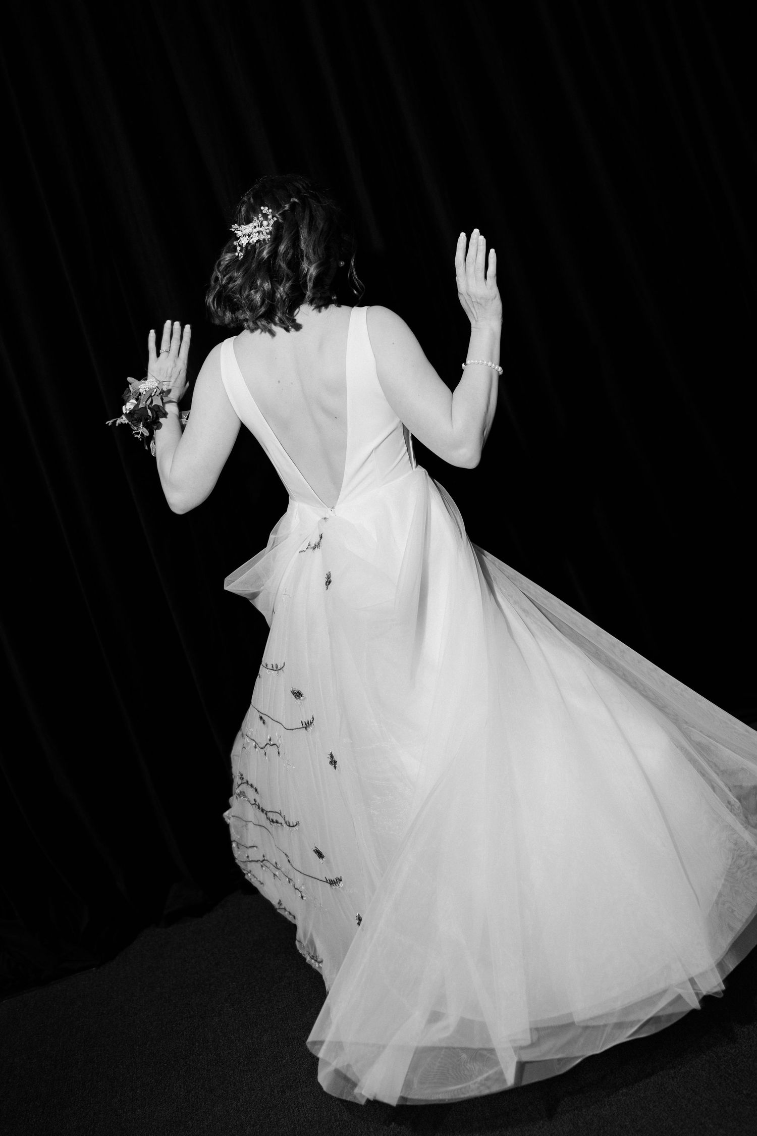 A flowing white dress twirls gracefully in a series of dramatic black and white dance movements against a dark background.