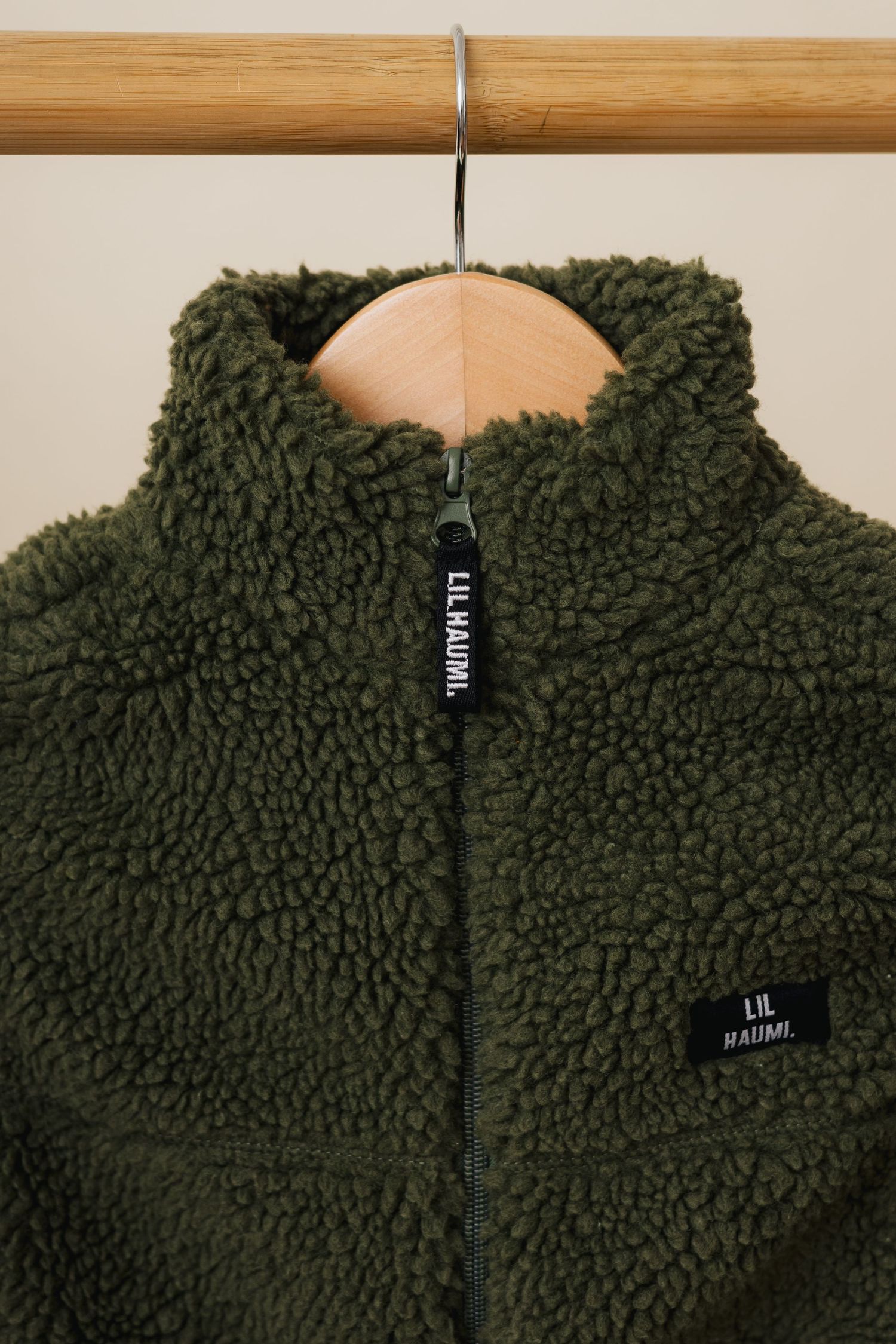 Close-up views of dark green sherpa fleece material with textured curly pile surface showing different angles and details.