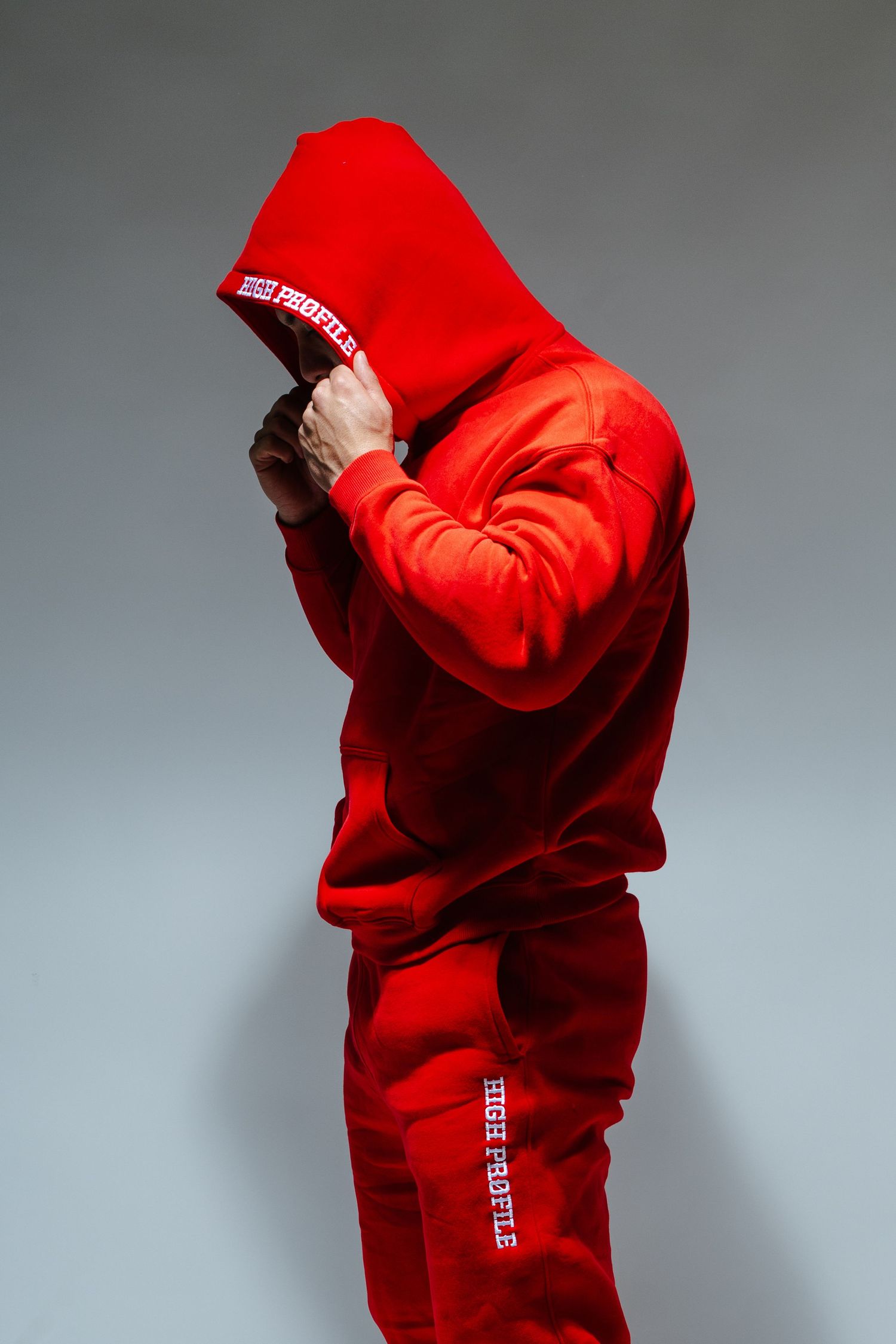 Red hoodie sweatshirt displayed in multiple angles on figure against gray backdrop.