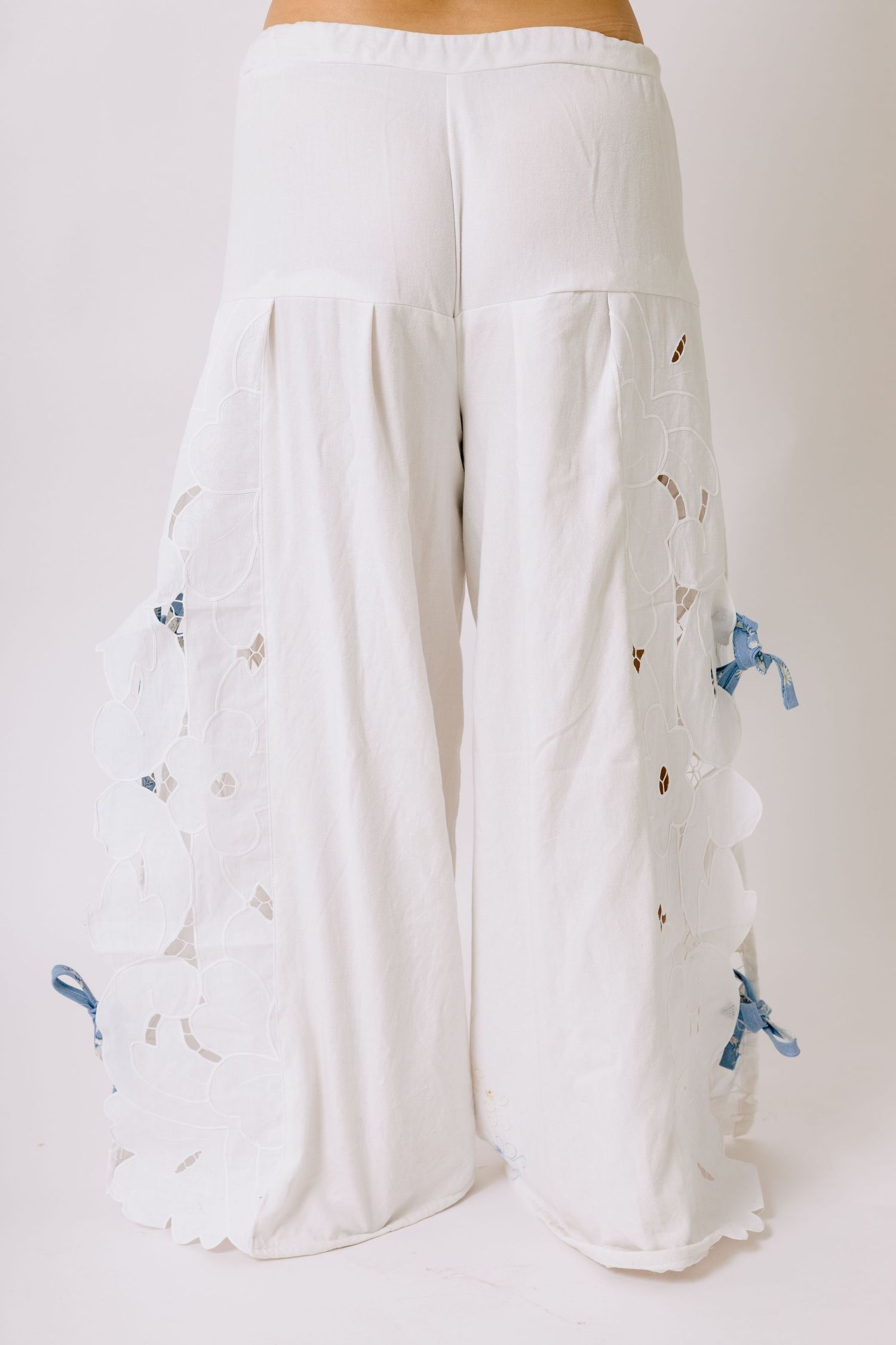 Flowy white palazzo pants with delicate blue butterfly embellishments scattered across the fabric.