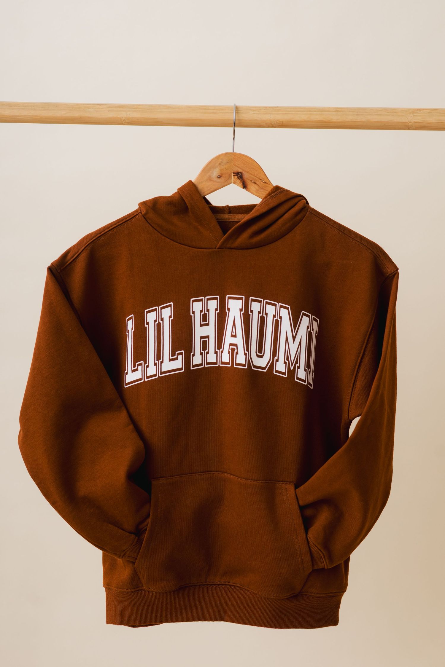 Brown cropped hoodie sweatshirt with 'Lil Haim' text displayed from different angles on white background.