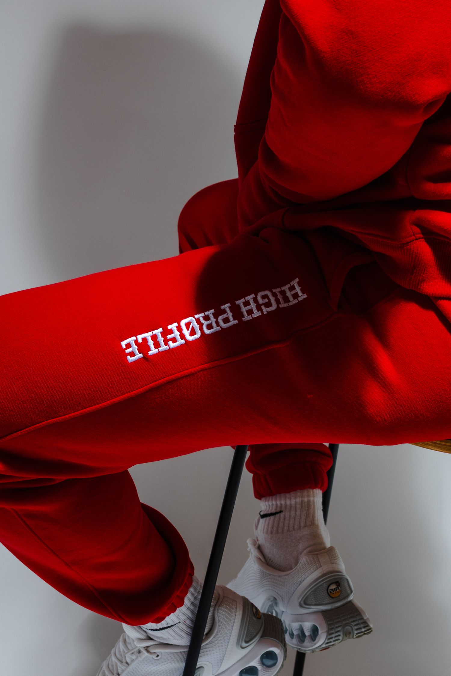 Red sweatshirt sleeve with white text detail shown at various angles.