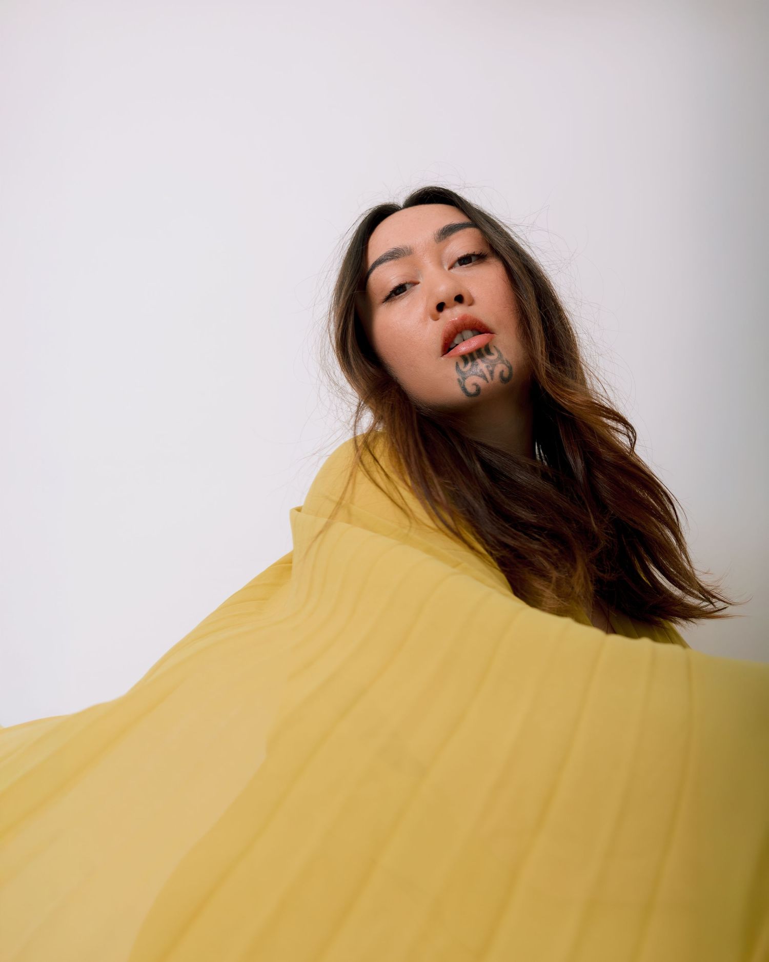 A fashion portrait series showing a model in a yellow outfit against a white background with dynamic poses.