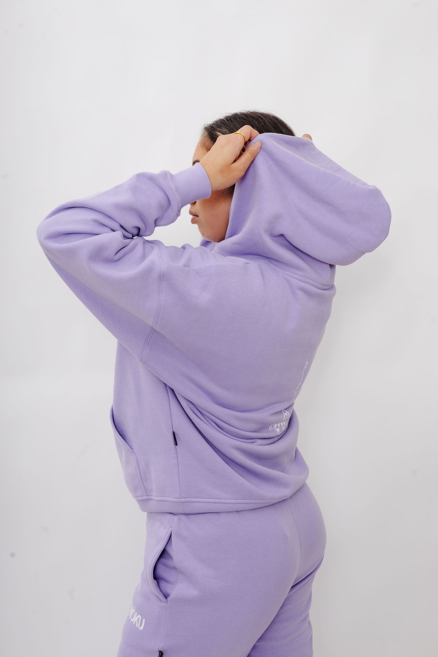 A person wearing a lavender colored hoodie and sweatpants set shown from multiple angles against a white background.