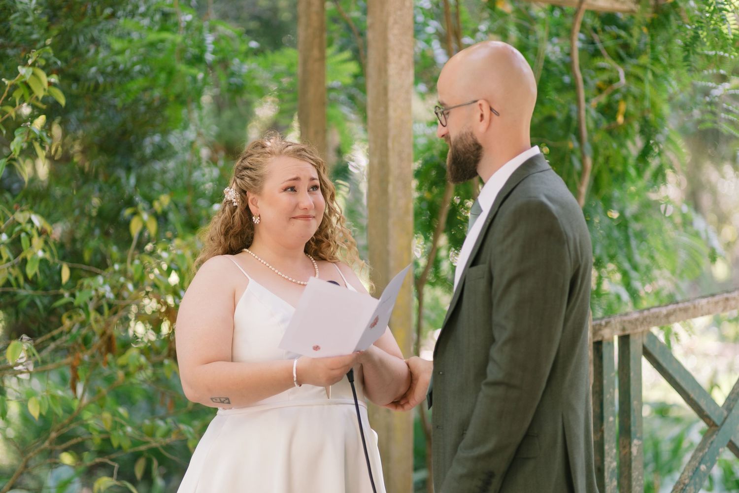 A couple exchanges vows during an intimate outdoor garden ceremony.