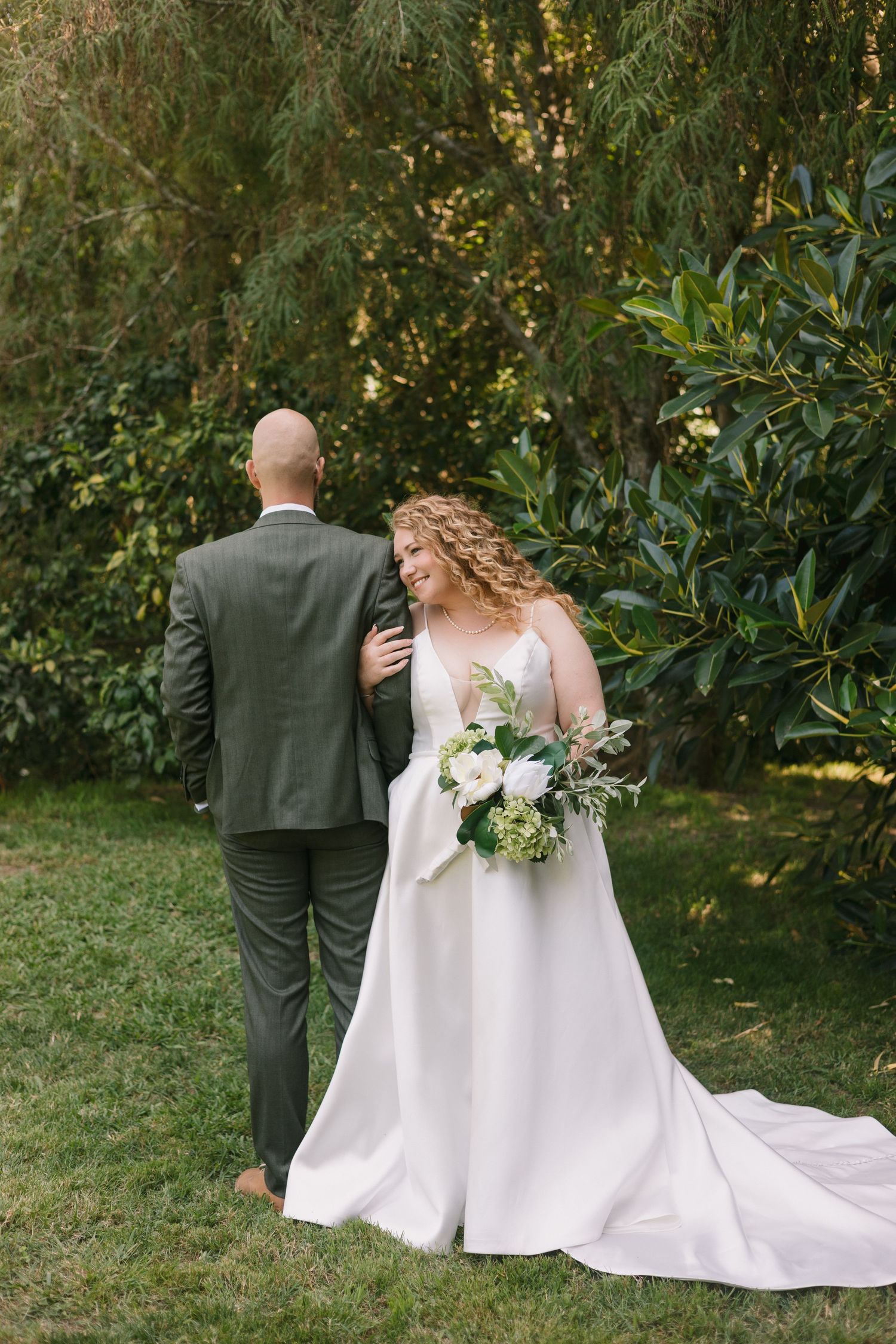 A series of wedding photos showing a couple walking on grass in front of green foliage with white dress and dark suit.