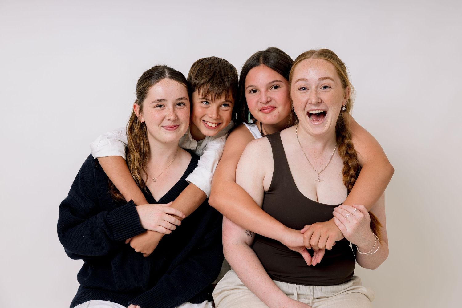 A group poses together in black dresses and formal attire for a professional photo shoot.