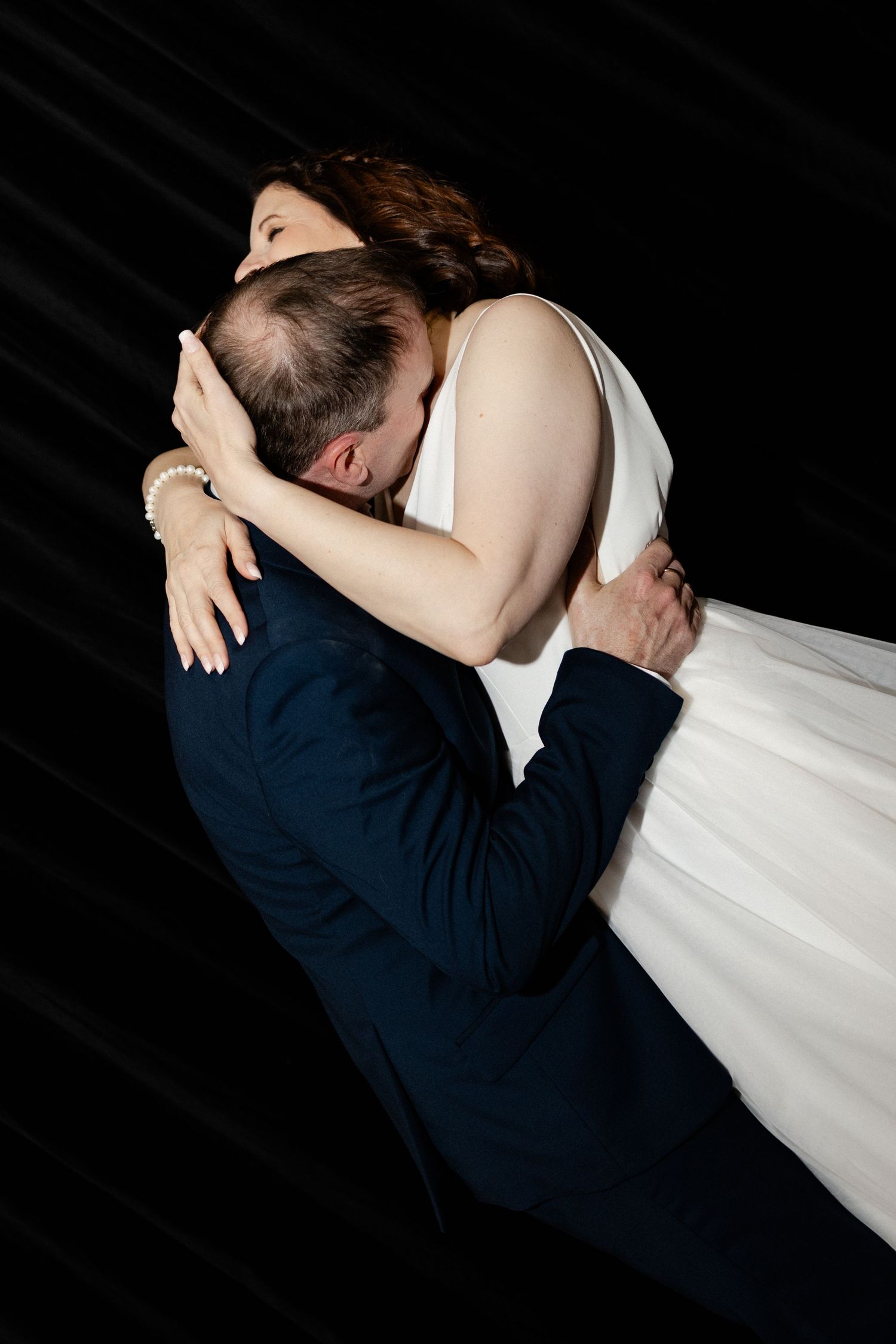 A romantic sequence of wedding photos showing a couple embracing in silhouette against a dark background.