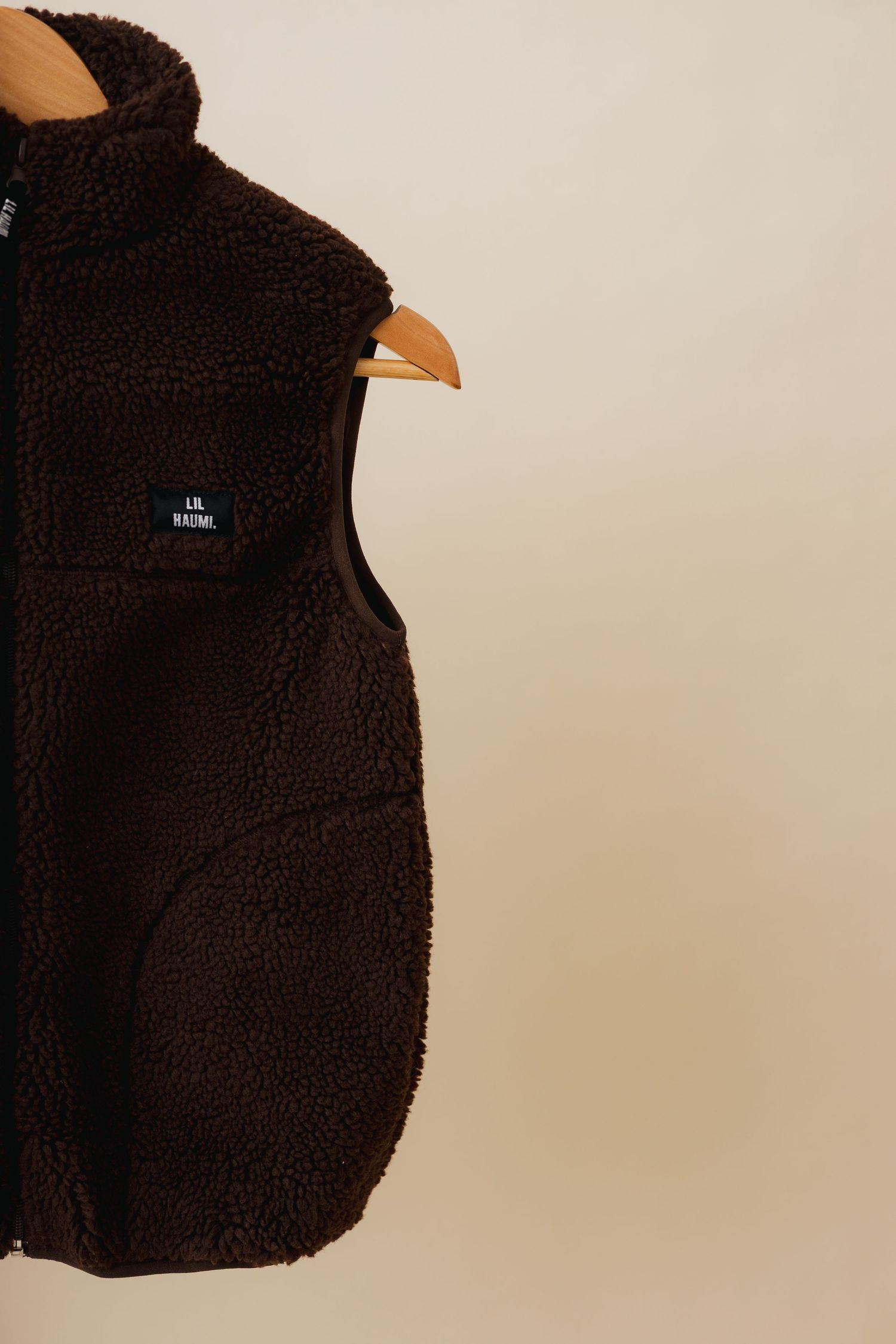 A series of close-up shots showing different angles of a black fleece jacket with a visible brand logo.
