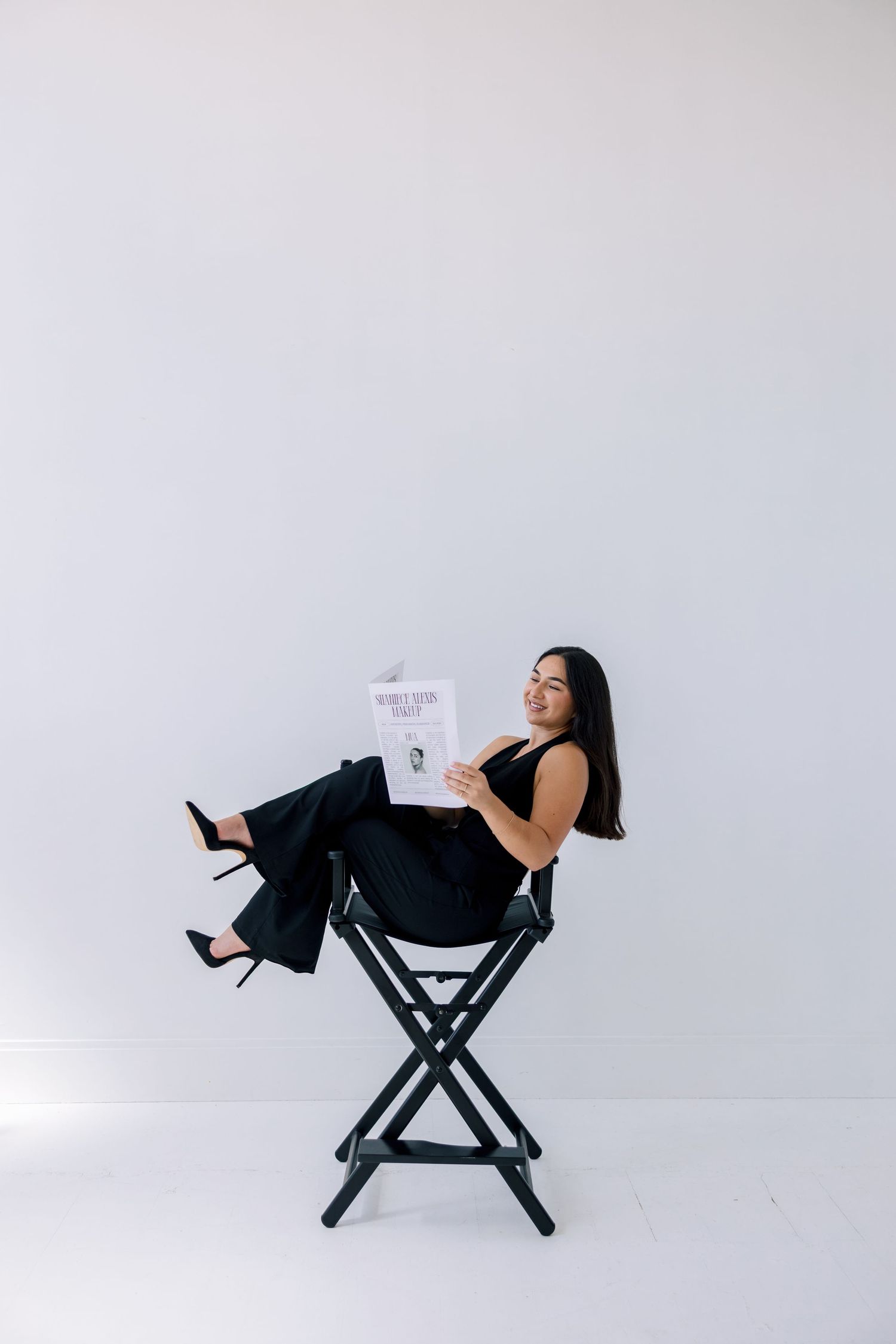 A series of photos showing someone sitting in a black director's chair against a white backdrop reading a script.