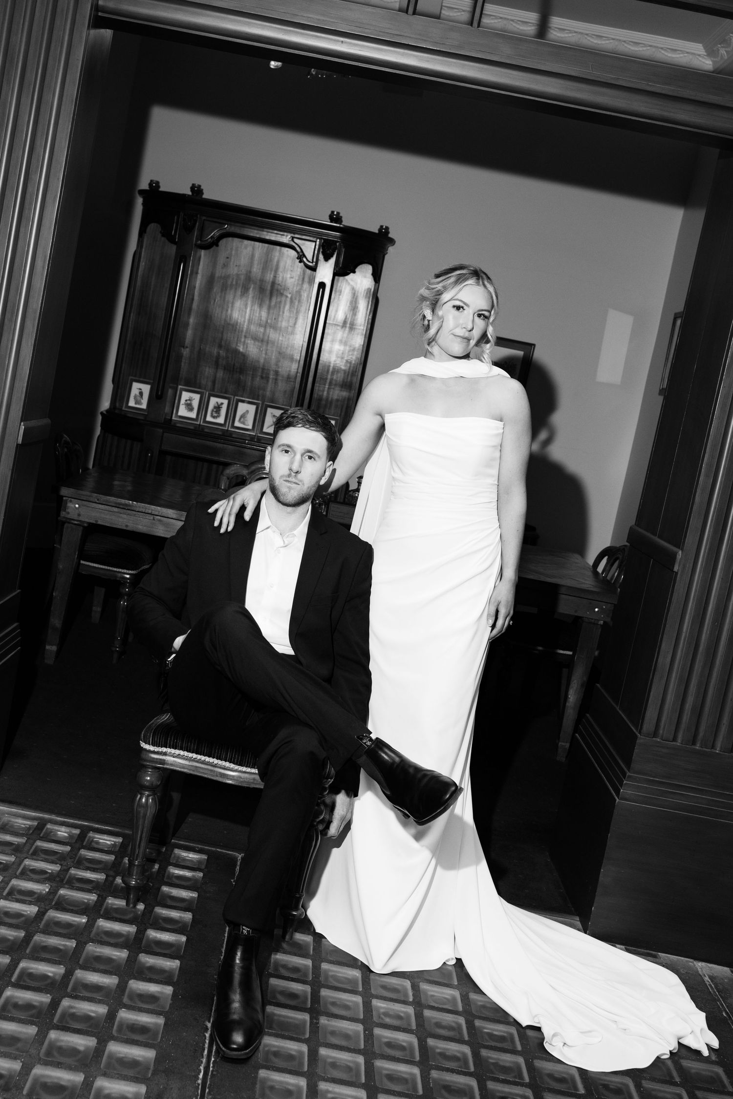A sequence of black and white wedding photos showing playful poses against a dark hallway background.