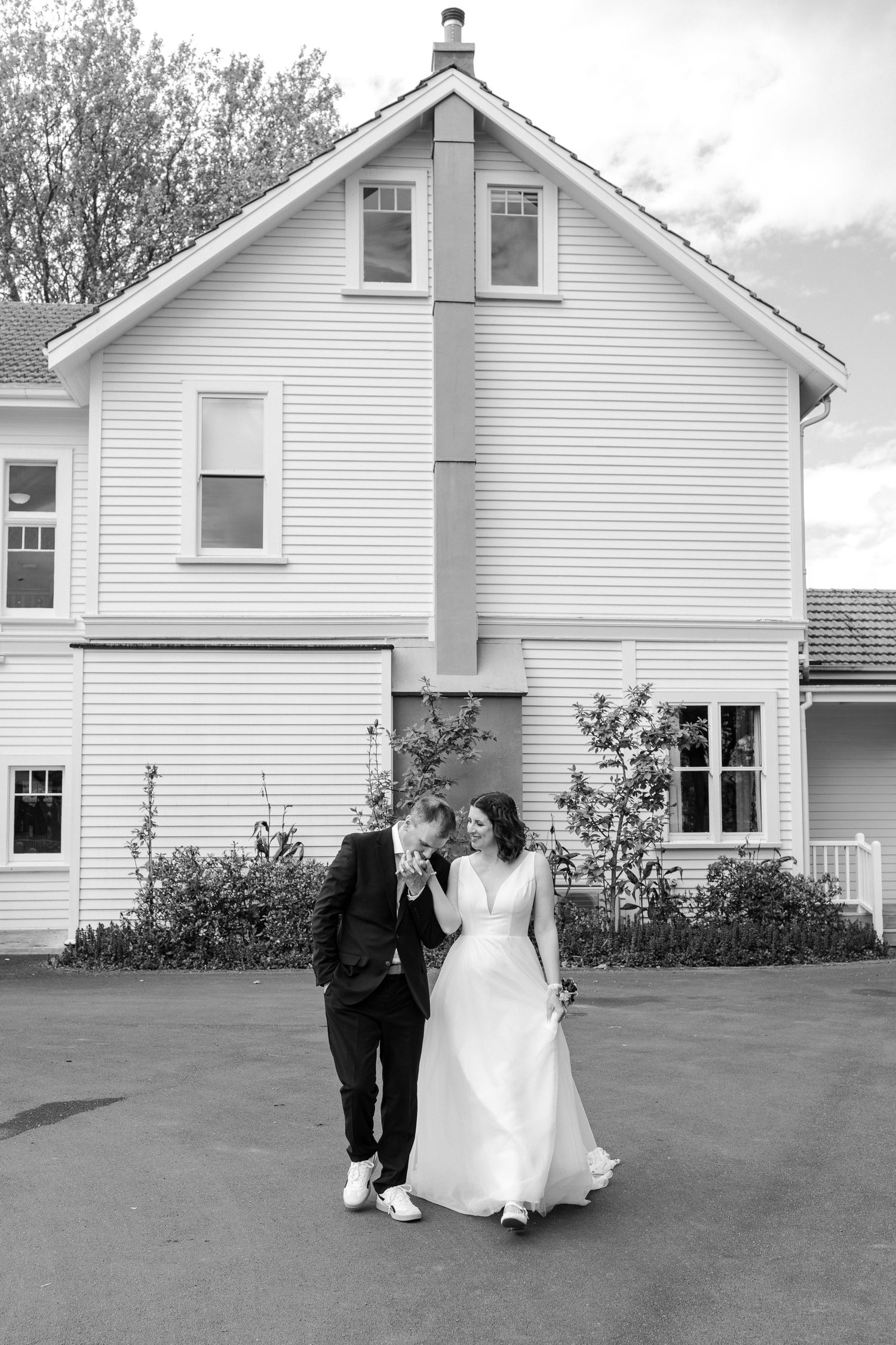 A series of wedding photos with a couple walking in front of white farmhouse buildings.