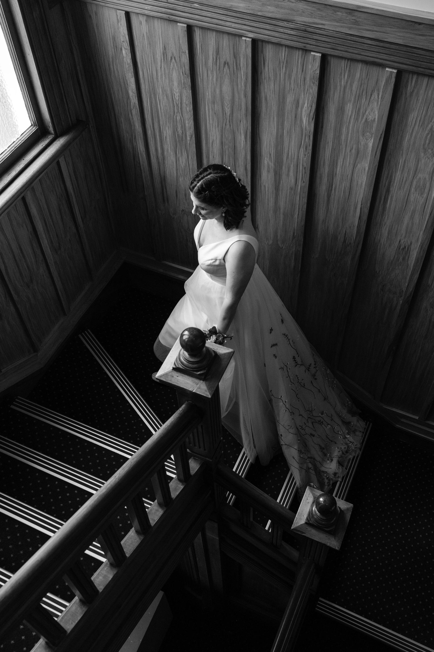 A series of moody black and white photographs showing someone ascending wooden stairs in a vintage-style dress.