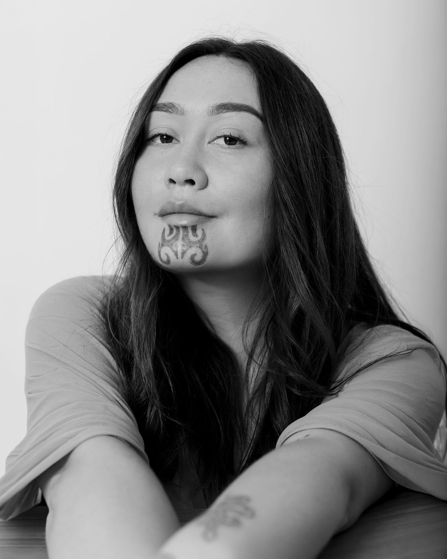 Black and white portrait series showing artistic facial expressions and poses with traditional Maori-inspired face paint designs.