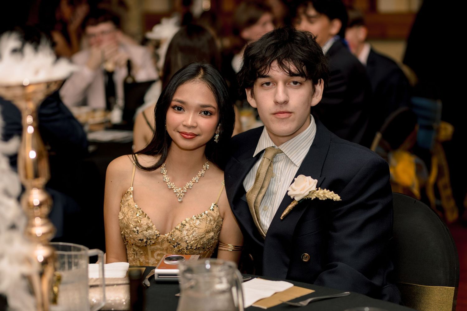 Young couple dressed in formal attire posing together at a prom or gala event.