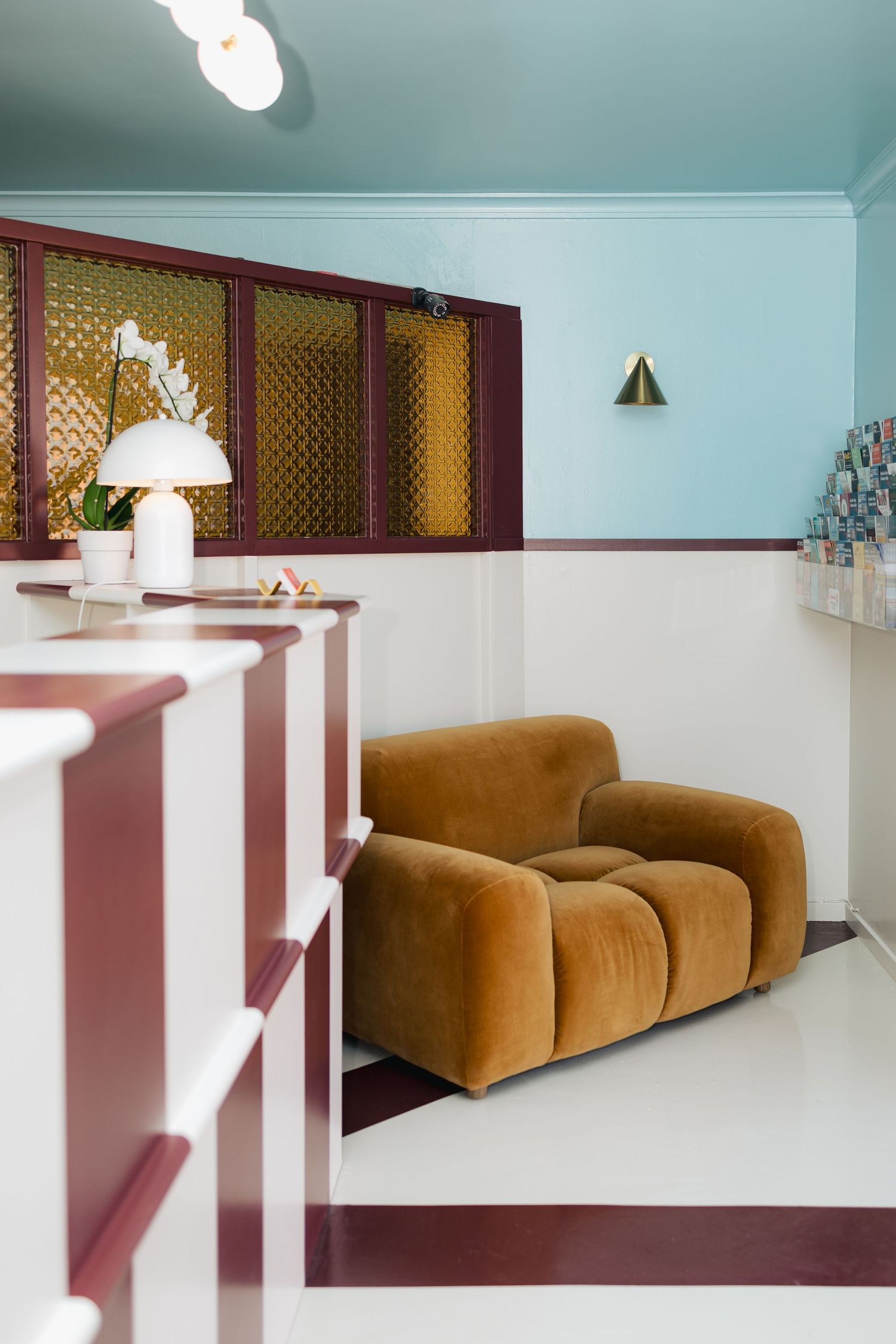 Retro lounge area with brown velvet sofa and decorative wall screens.