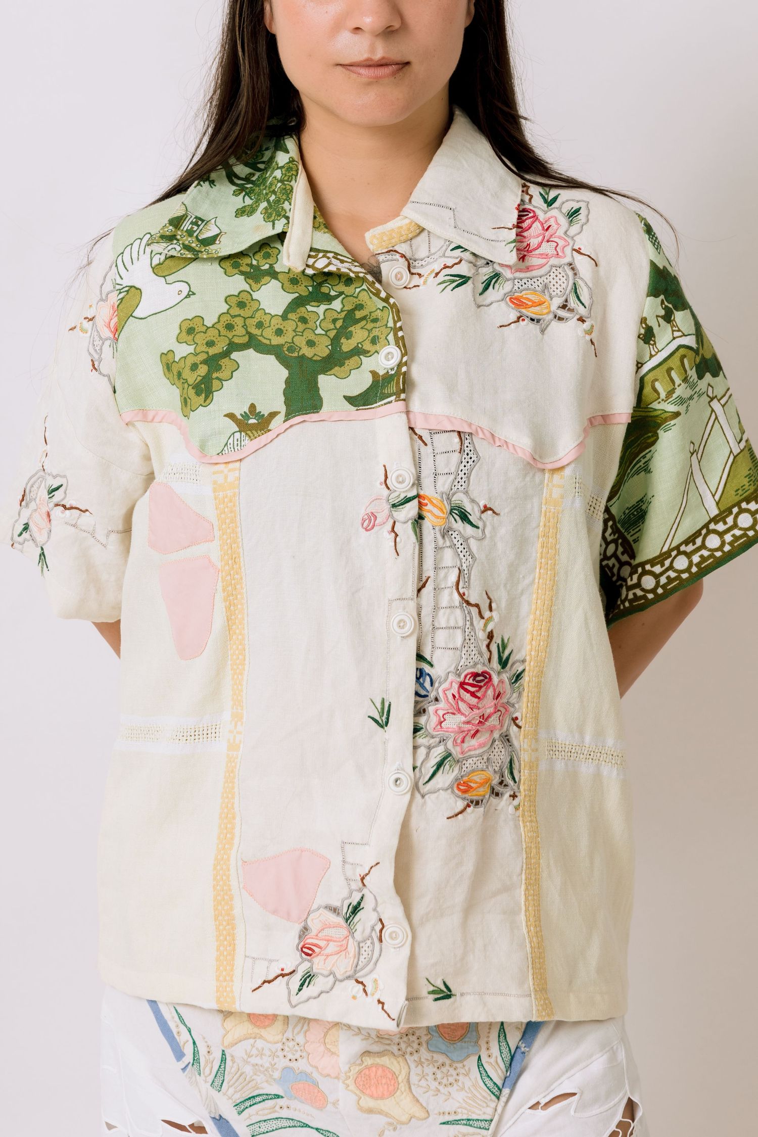 Vintage-inspired button-up shirt with floral and botanical print in soft cream, green and pink tones.
