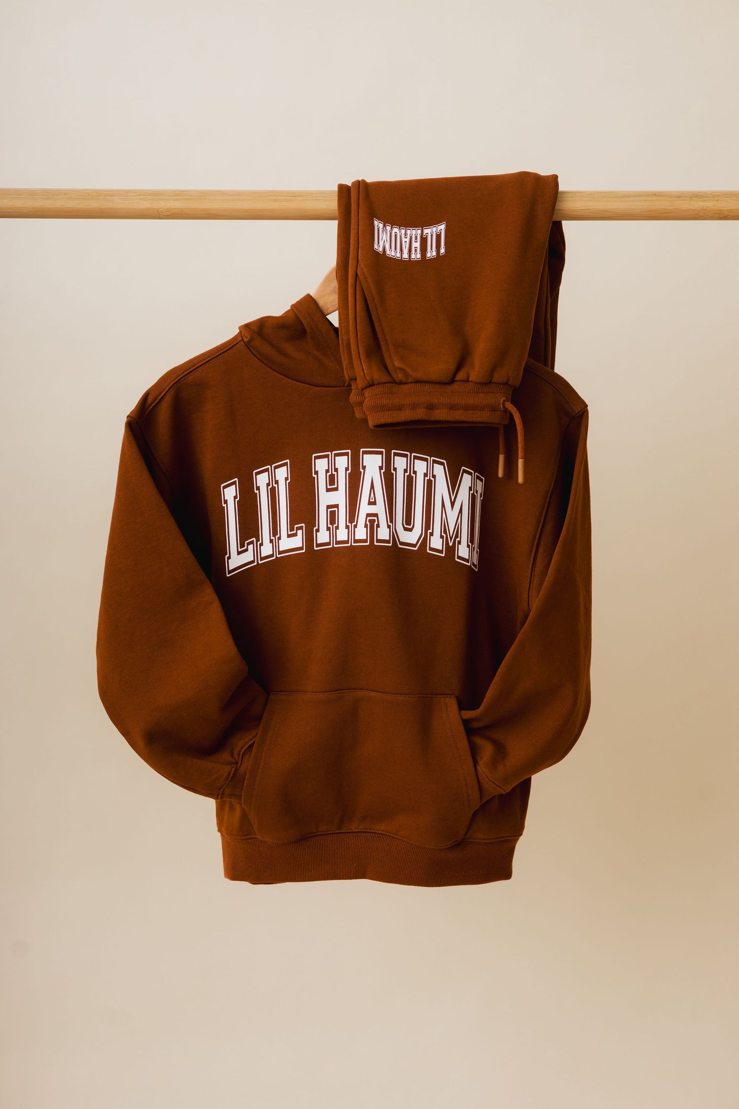 Brown collegiate-style hoodie sweatshirt with white text logo shown from multiple angles on display.