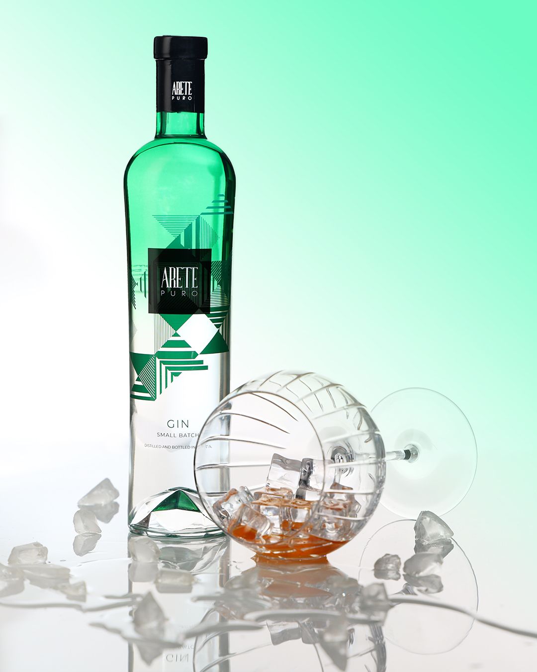Reklamna promotivna fotografija za gin. Boca gina i čaša u refleksiji