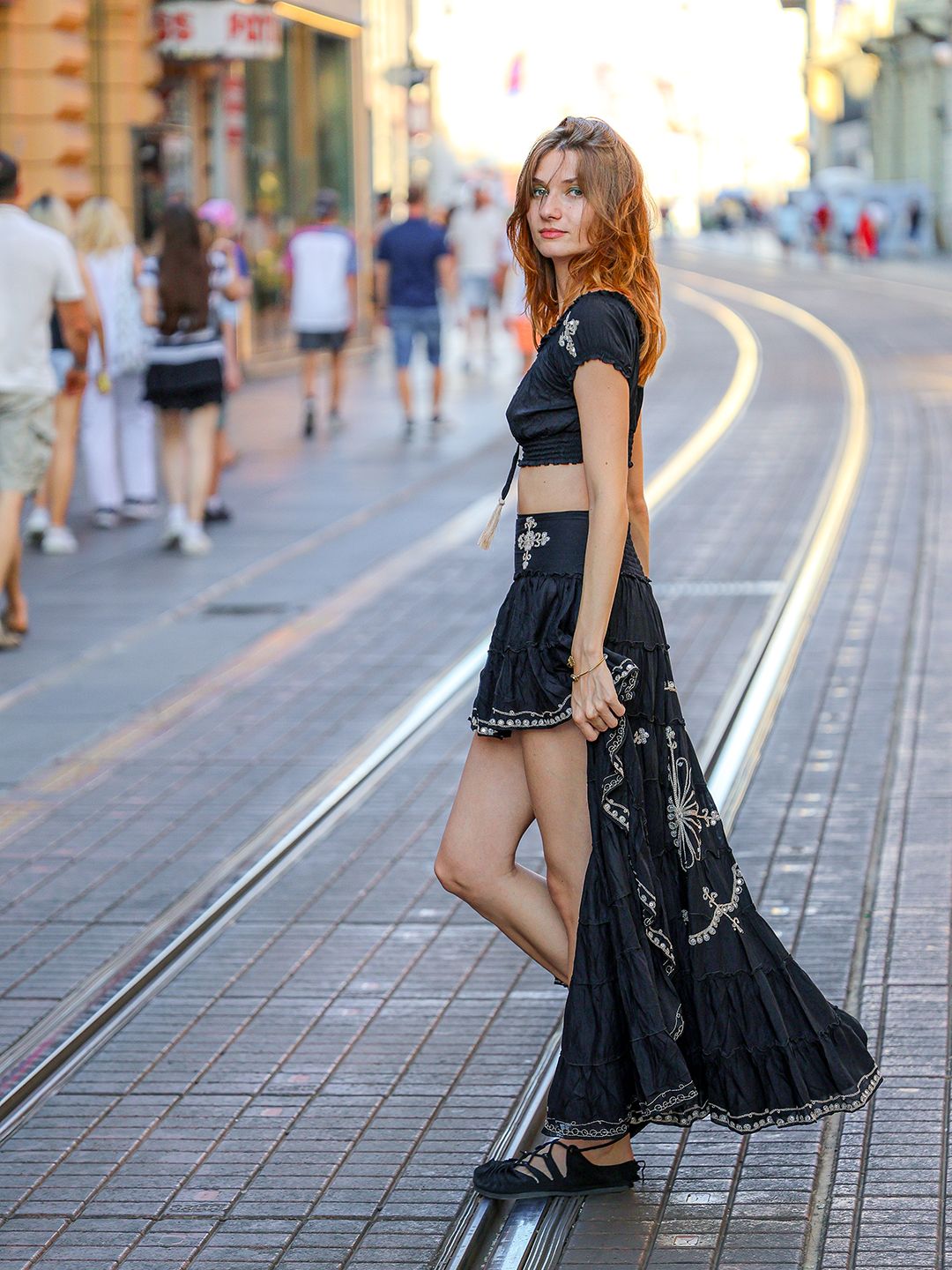 Modna fotografija modela u crnoj haljini na urbanoj lokaciji