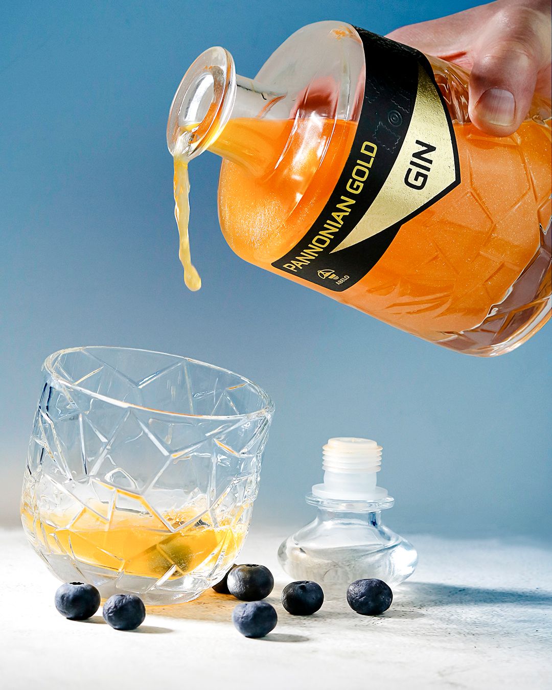 Reklamna fotografija za gin sa zlatnim listićima. Kontrast boja