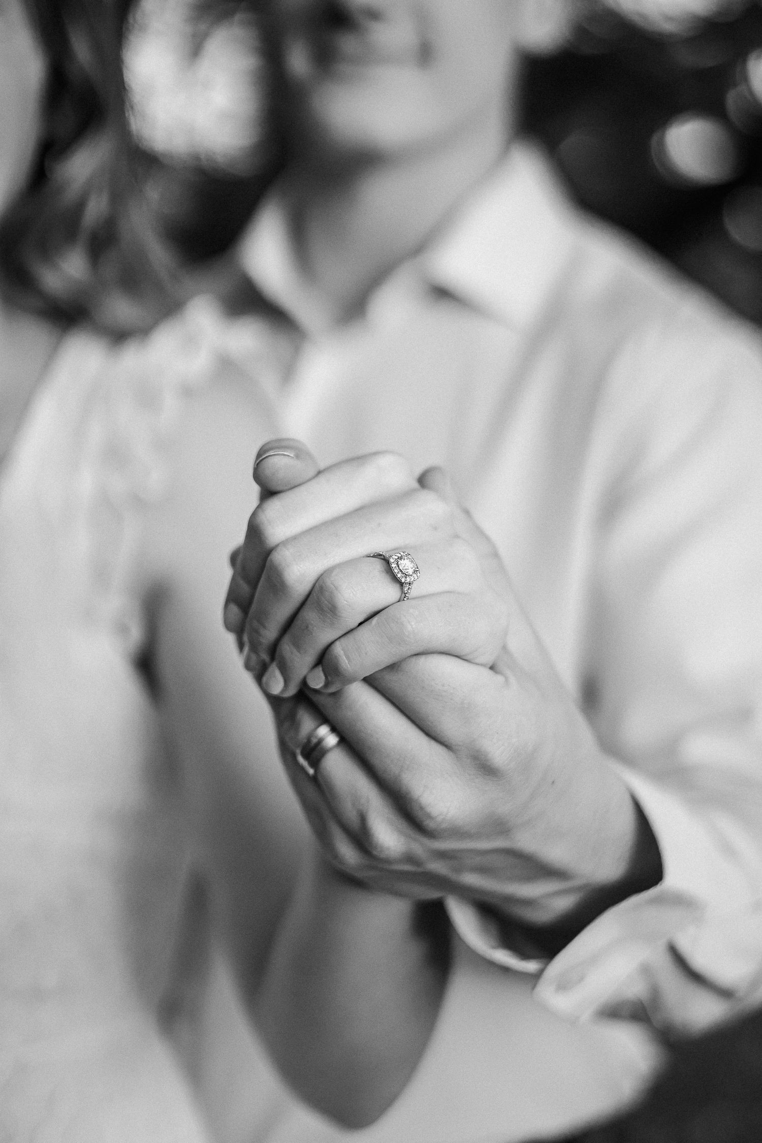A series of black and white photographs showing clasped hands in white sleeves against a blurred background.