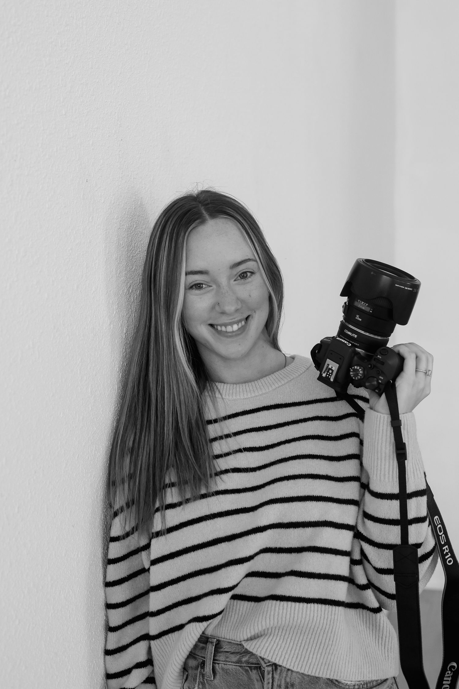 A series of four similar photos showing someone in a striped sweater posing with a camera against a white background.