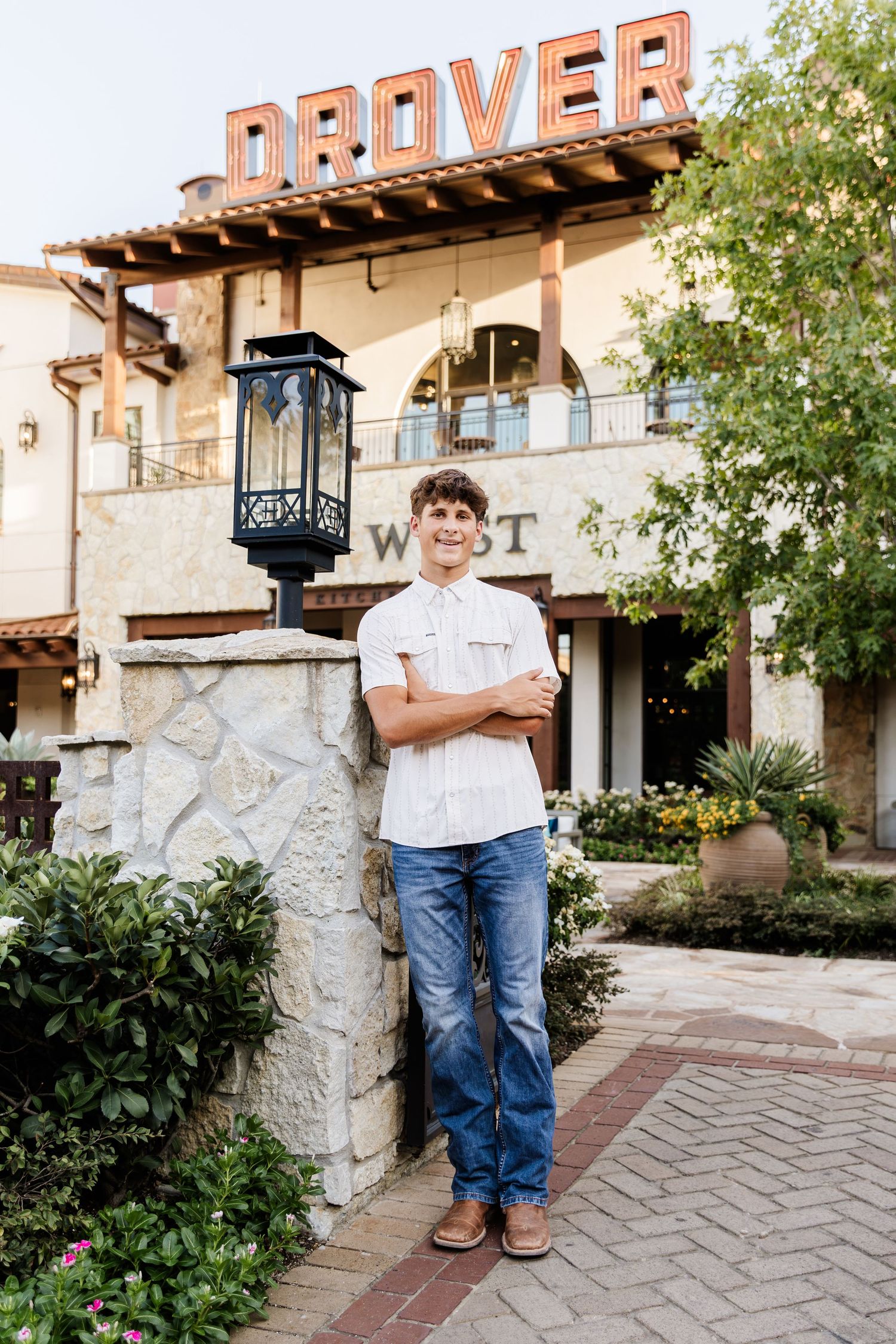 Young man in white shirt and jeans standing confidently outside the Drover Hotel in Fort Worth, Texas.
