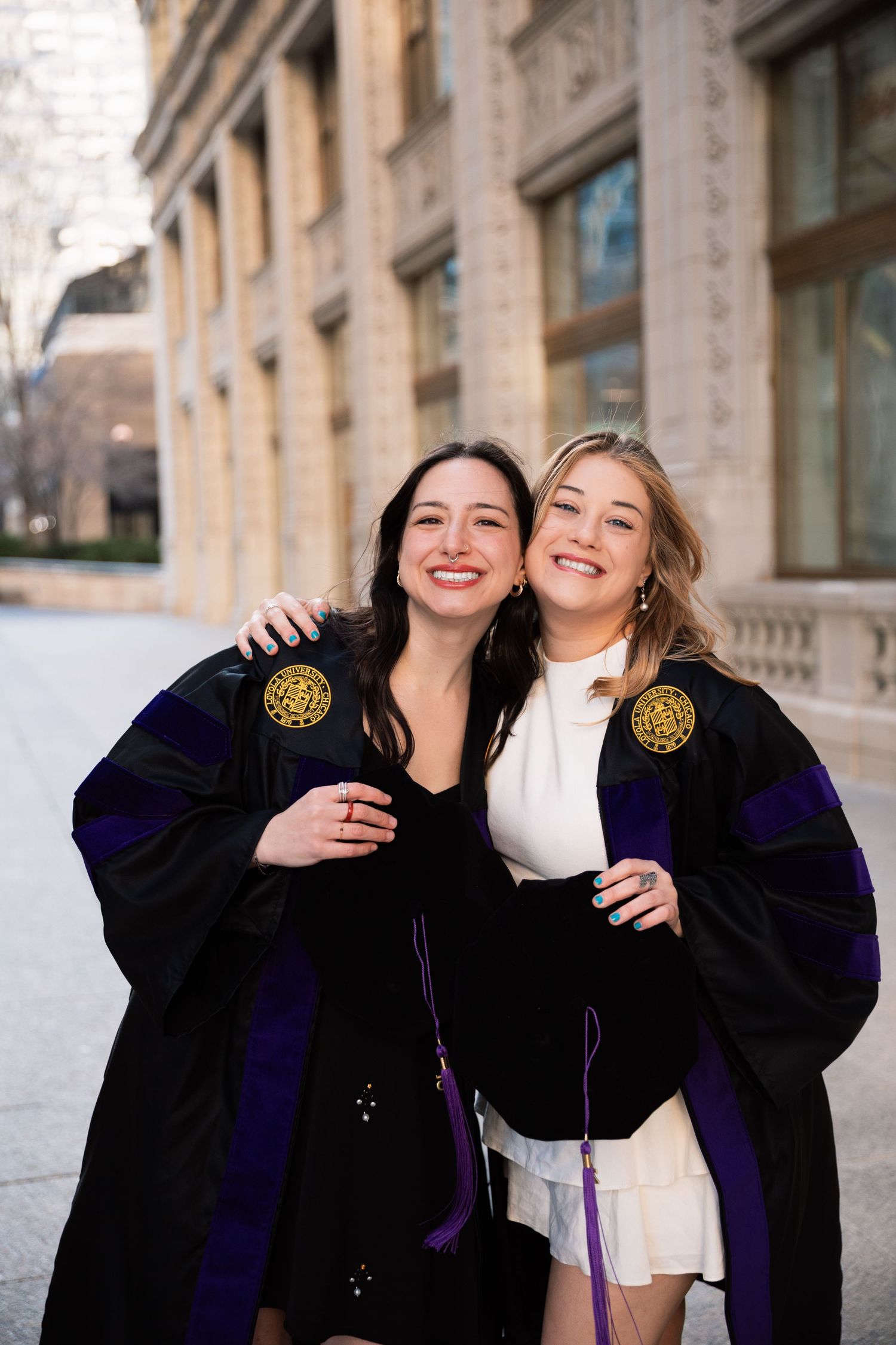 Happy graduates embracing and celebrating in their academic regalia.