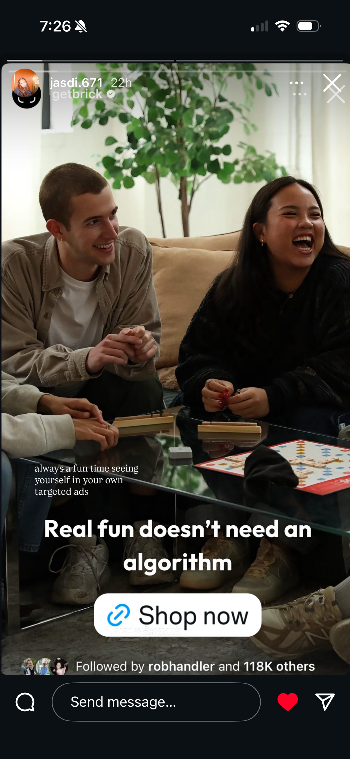 Two friends laughing and playing a board game on a living room floor, featured in a Beltrick social media ad.