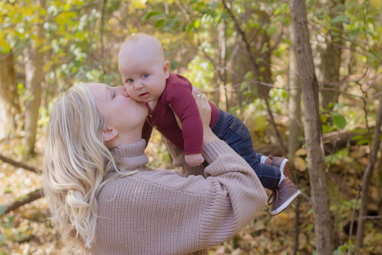 Parent and baby sharing a tender moment during an autumn photoshoot.