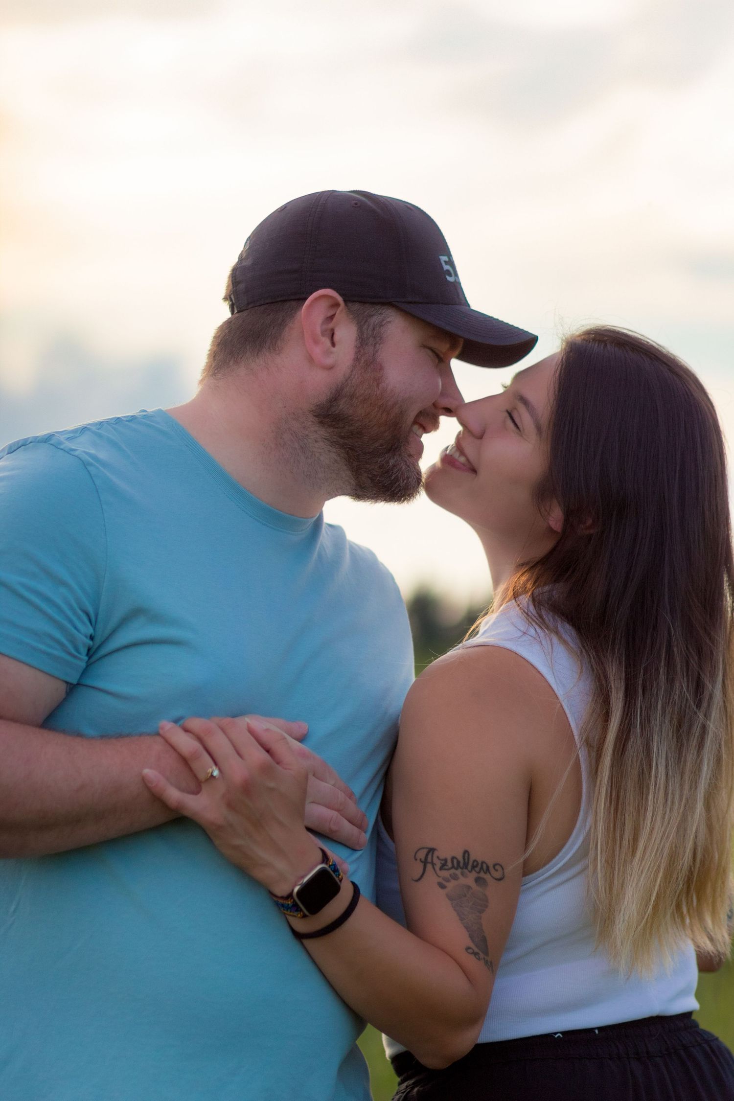 A loving couple shares an intimate moment at sunset, with soft lighting illuminating their tender embrace.