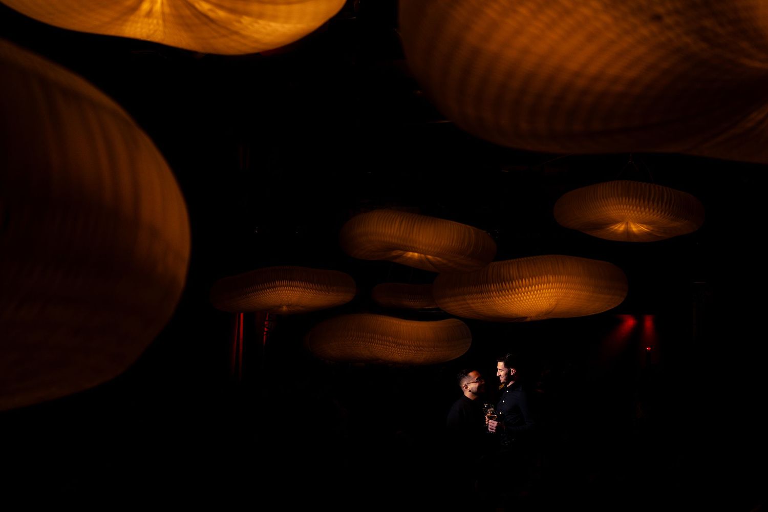 Warm glowing lighting fixtures casting dramatic shadows in a dark space.