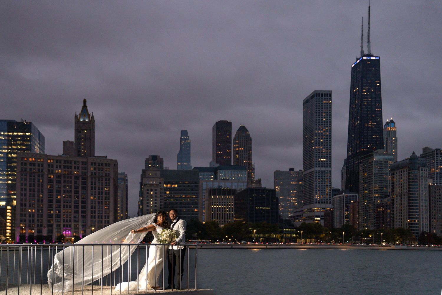 Dramatic wedding portrait with Chicago skyline and stormy sky at dusk.