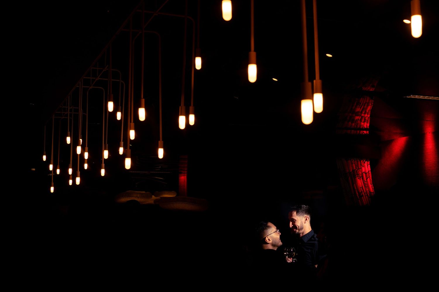 Romantic candlelit setting with hanging pendant lights creating an intimate atmosphere.