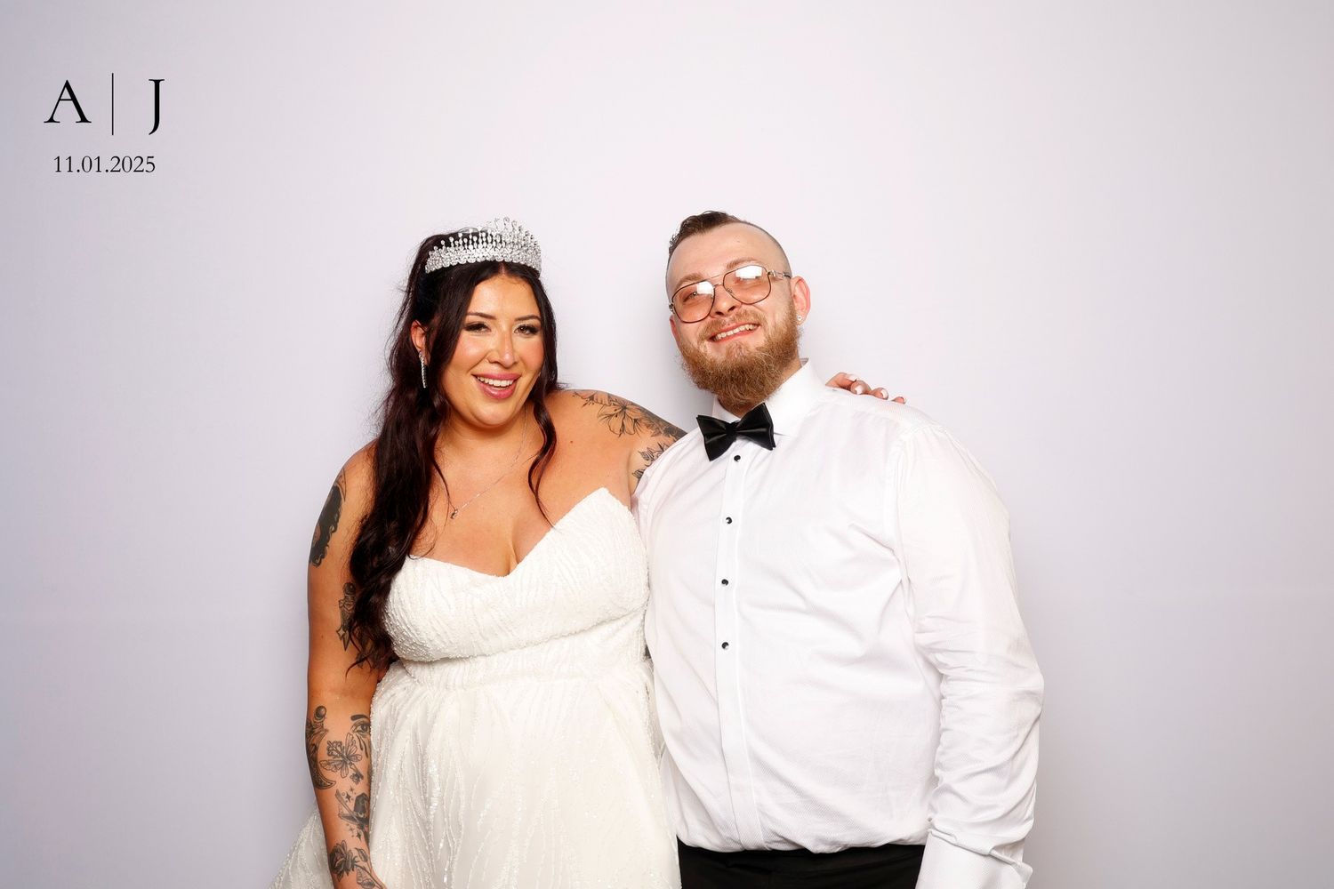 A bride and groom pose together at a photo booth during their wedding celebration.