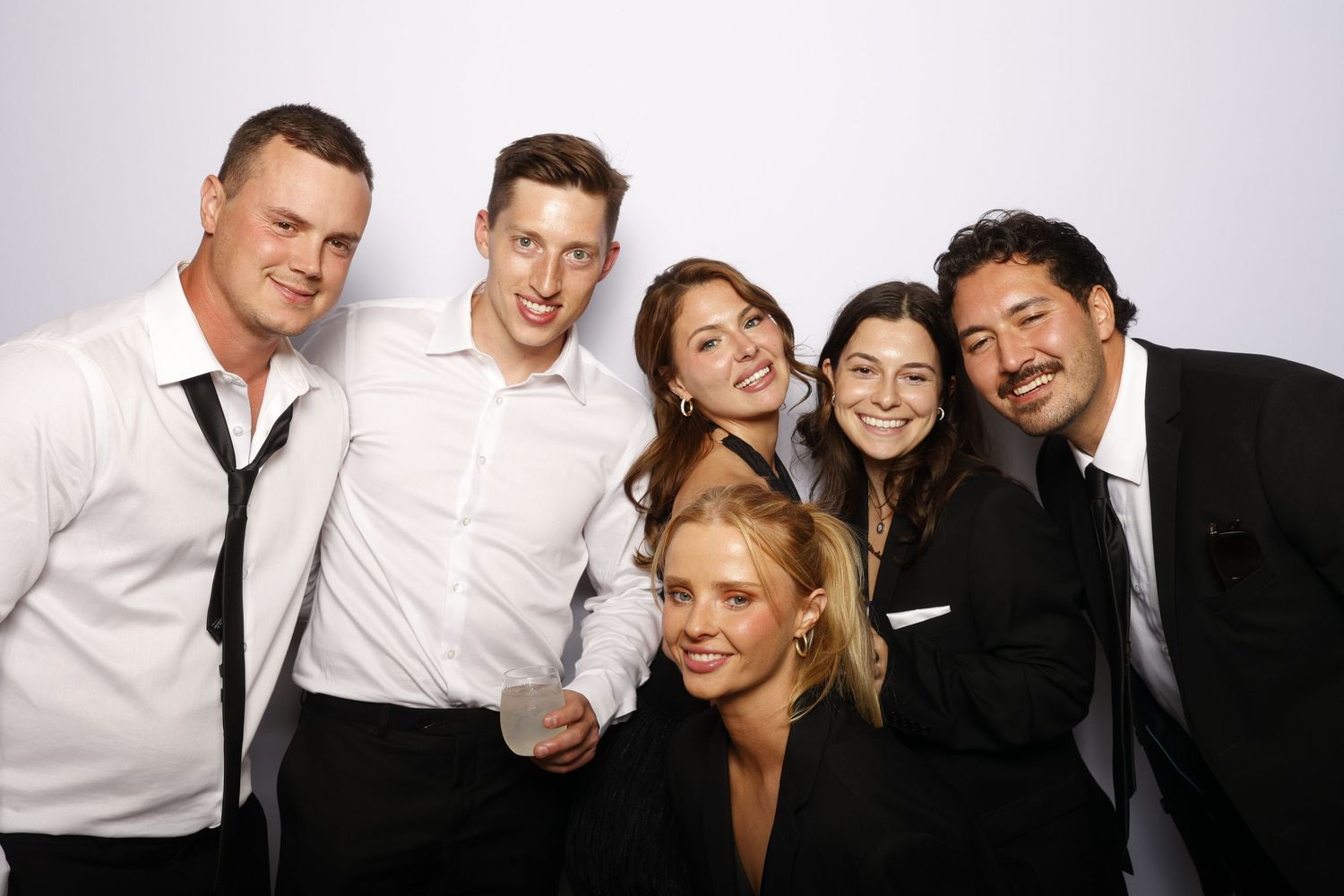 A collection of black and white photo booth strips showing groups of people having fun and making silly poses.
