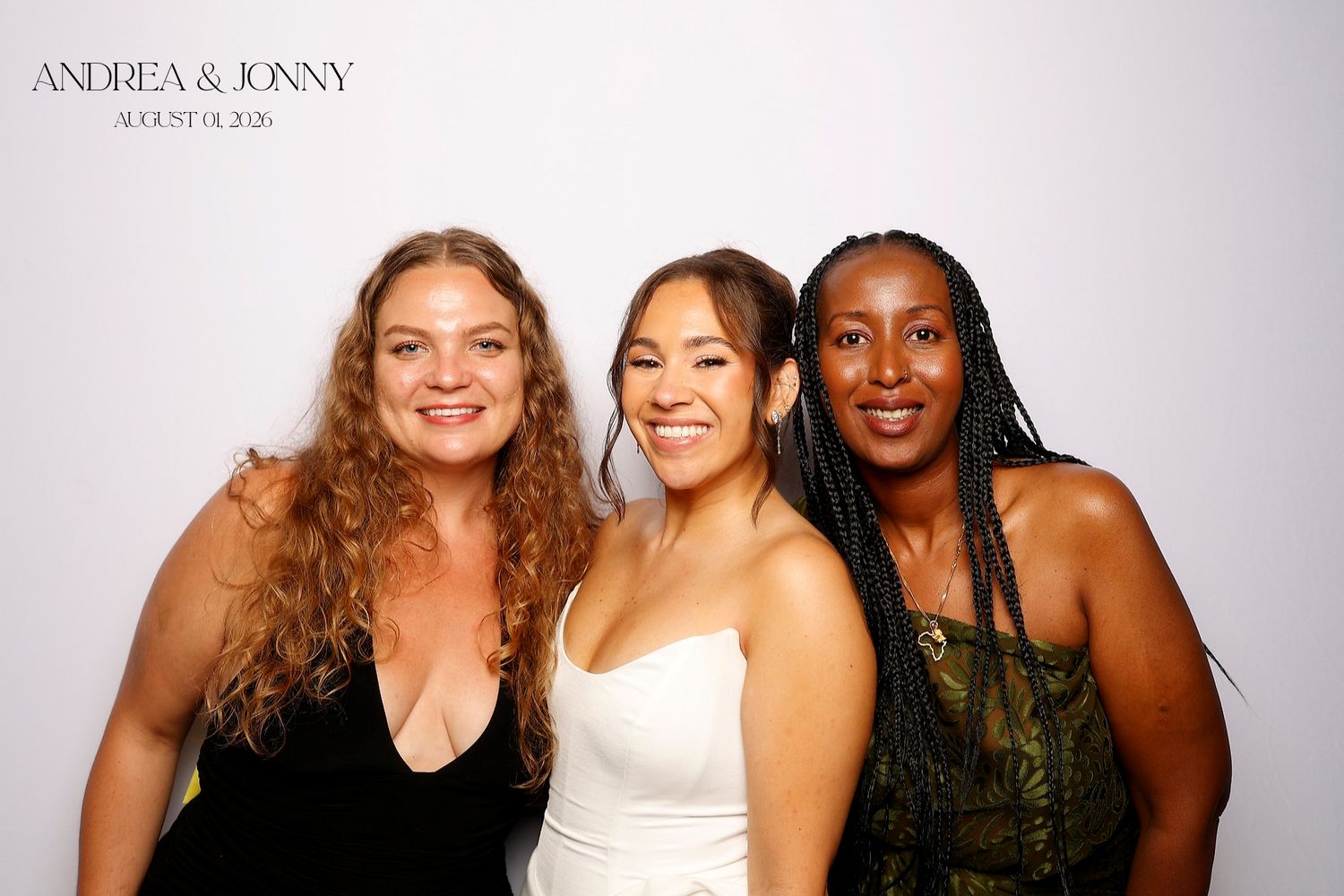 Three women smiling together at Andrea and Jonny wedding photo booth, August 2025.