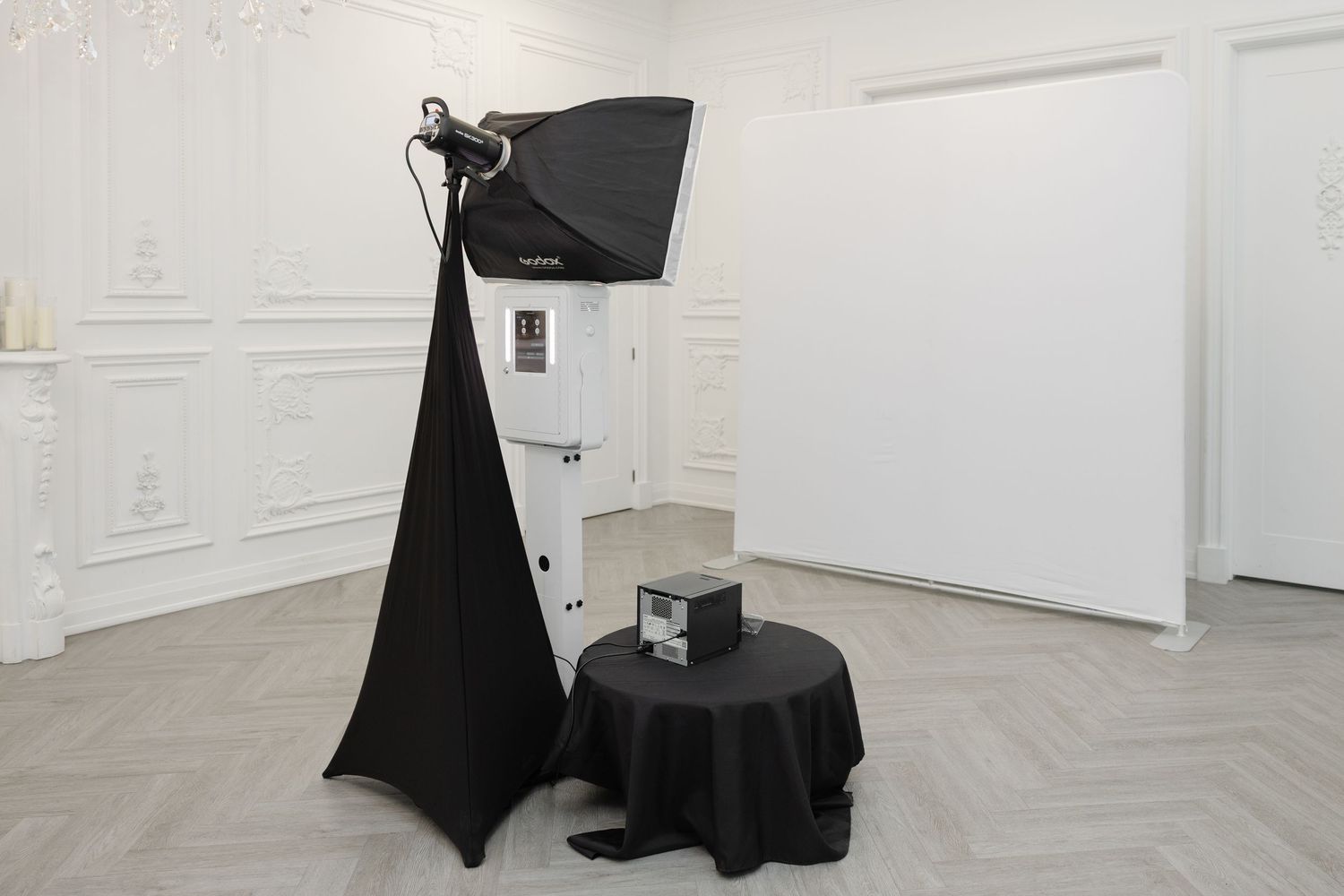 White gallery walls display minimalist artwork with black fabric installations creating a modern exhibition space.