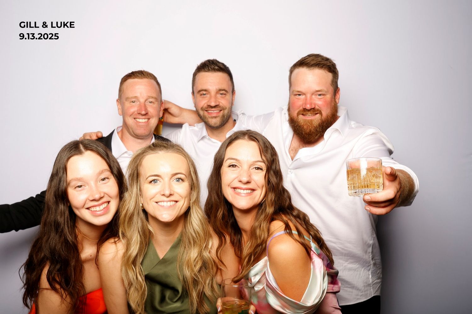 Group of friends smiling and posing together at a photo booth event.