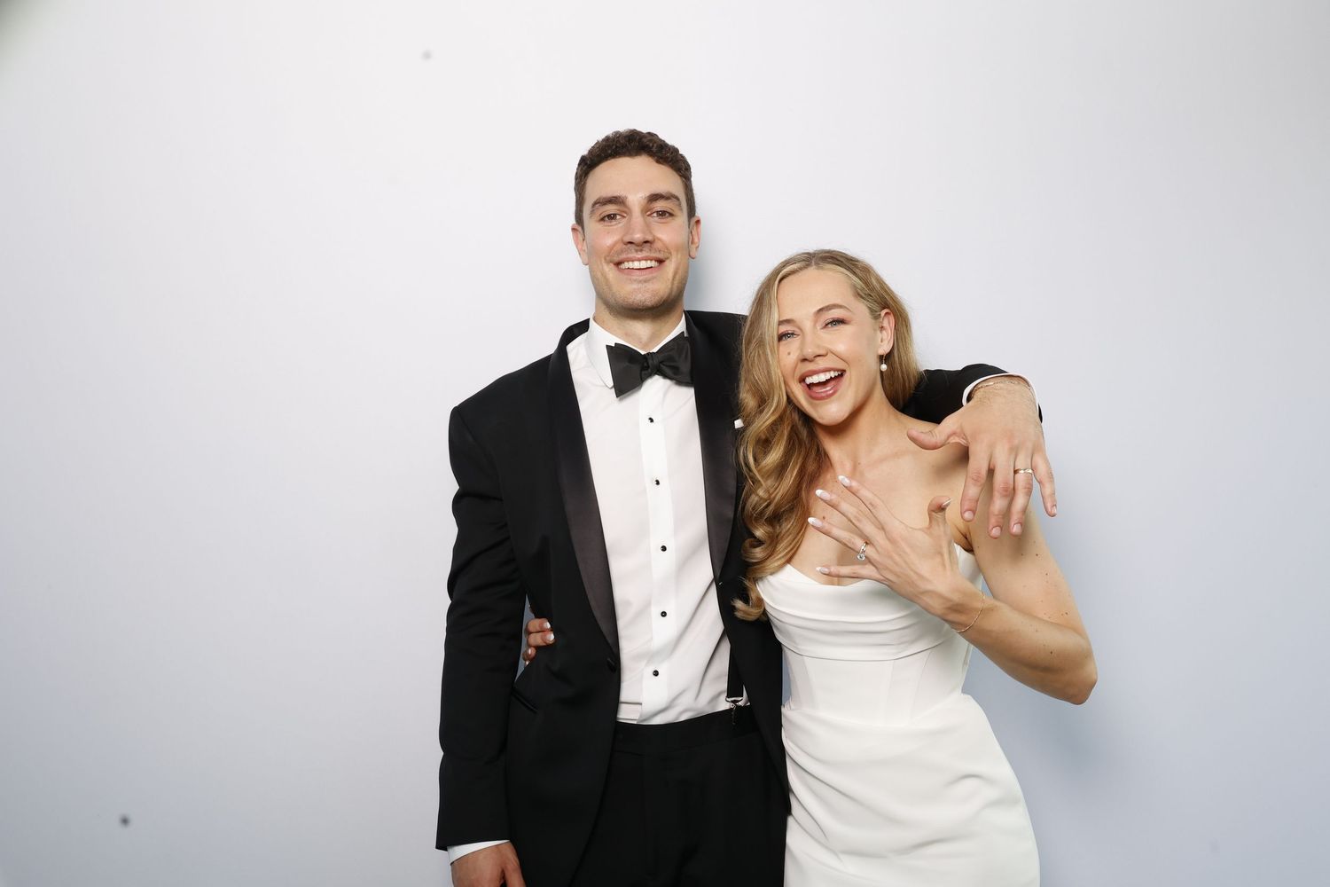 A wedding couple poses for a series of playful and candid photos in formal attire against a light background.