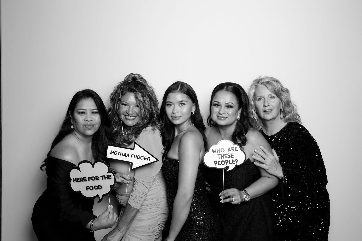 A series of black and white photo booth style snapshots showing friends posing and smiling together in different arrangements.