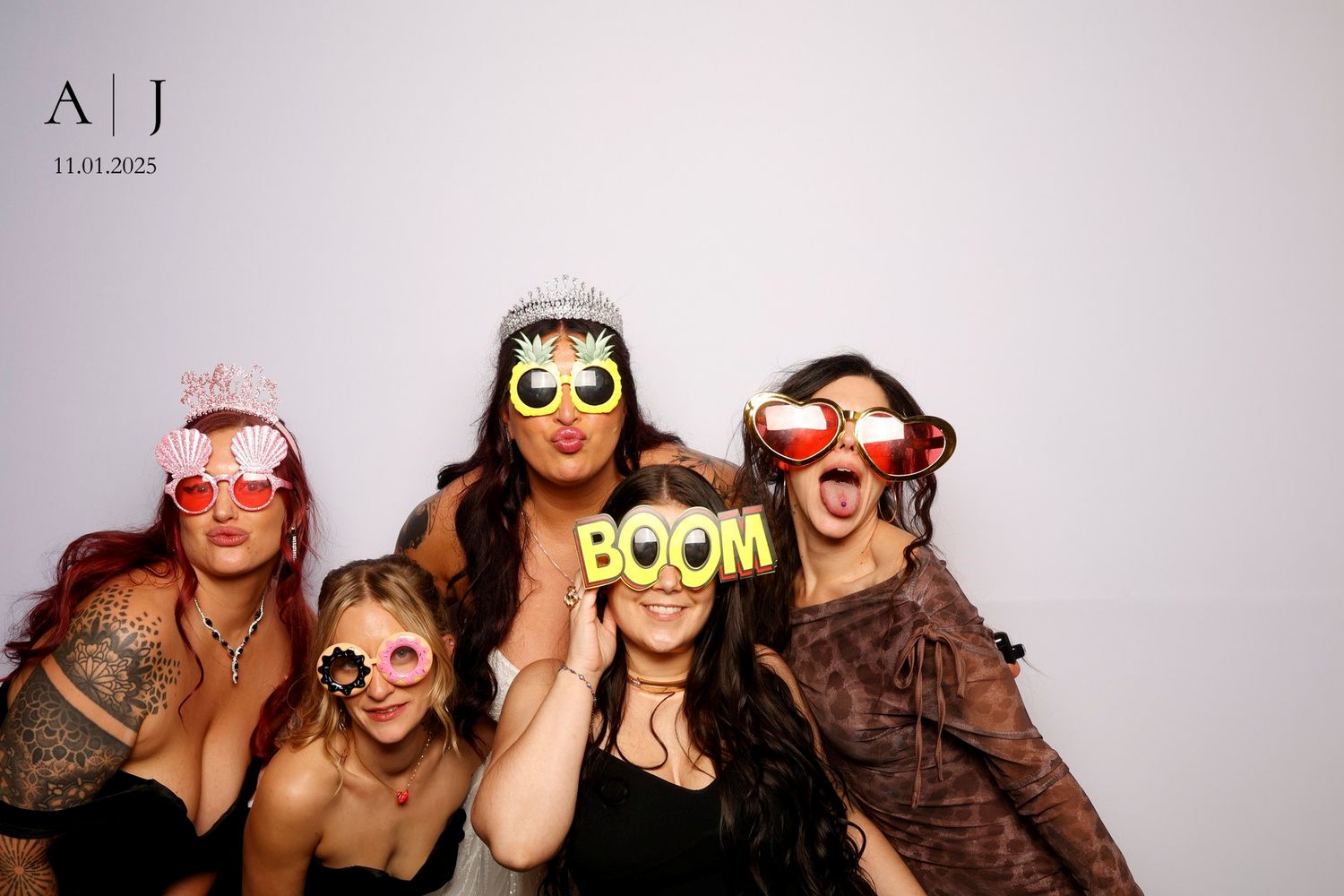 A group of people pose together in a photo booth wearing fun novelty glasses and accessories.