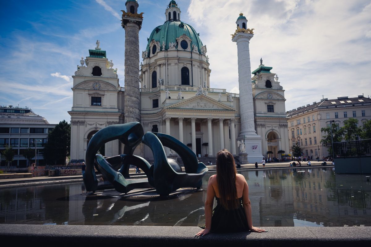 eine Dame geniesst einen Ausblick auf Karlskirche in Wien bei einer Führung mit Fotoshooting